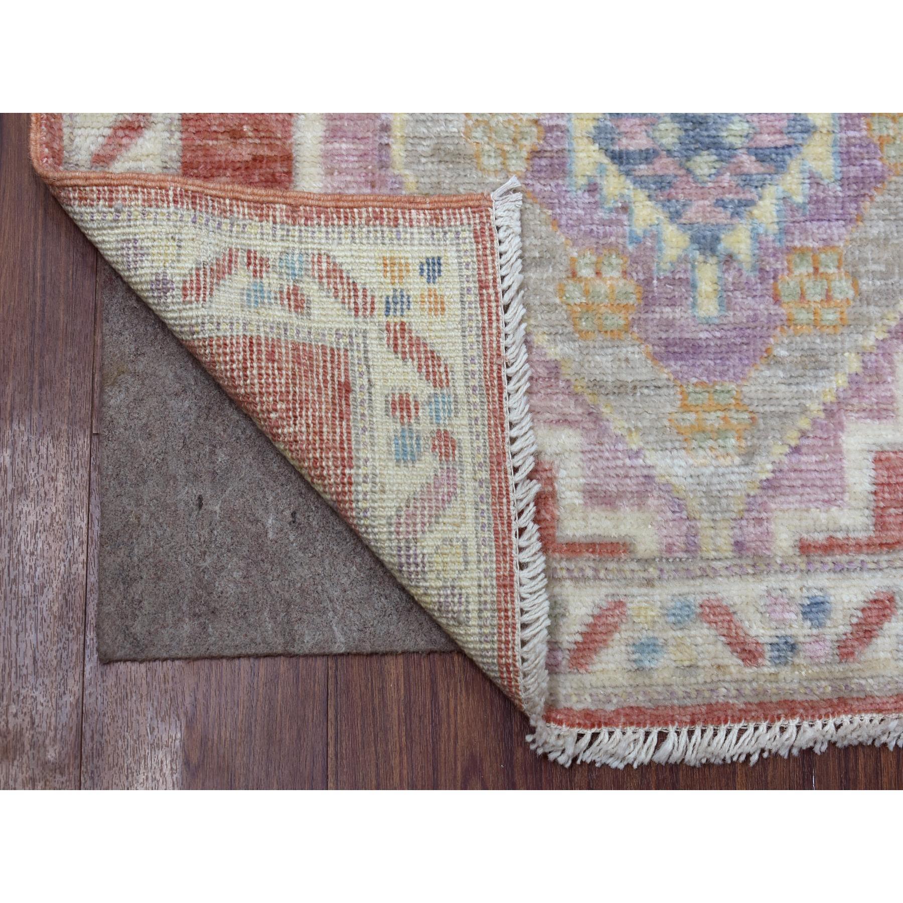 Il s'agit d'un véritable tapis de course oriental en laine douce nouée à la main, de couleur rouge corail, en angora afghan Oushak avec des médaillons géométriques. Il a été noué pendant des mois et des mois selon les techniques artisanales de