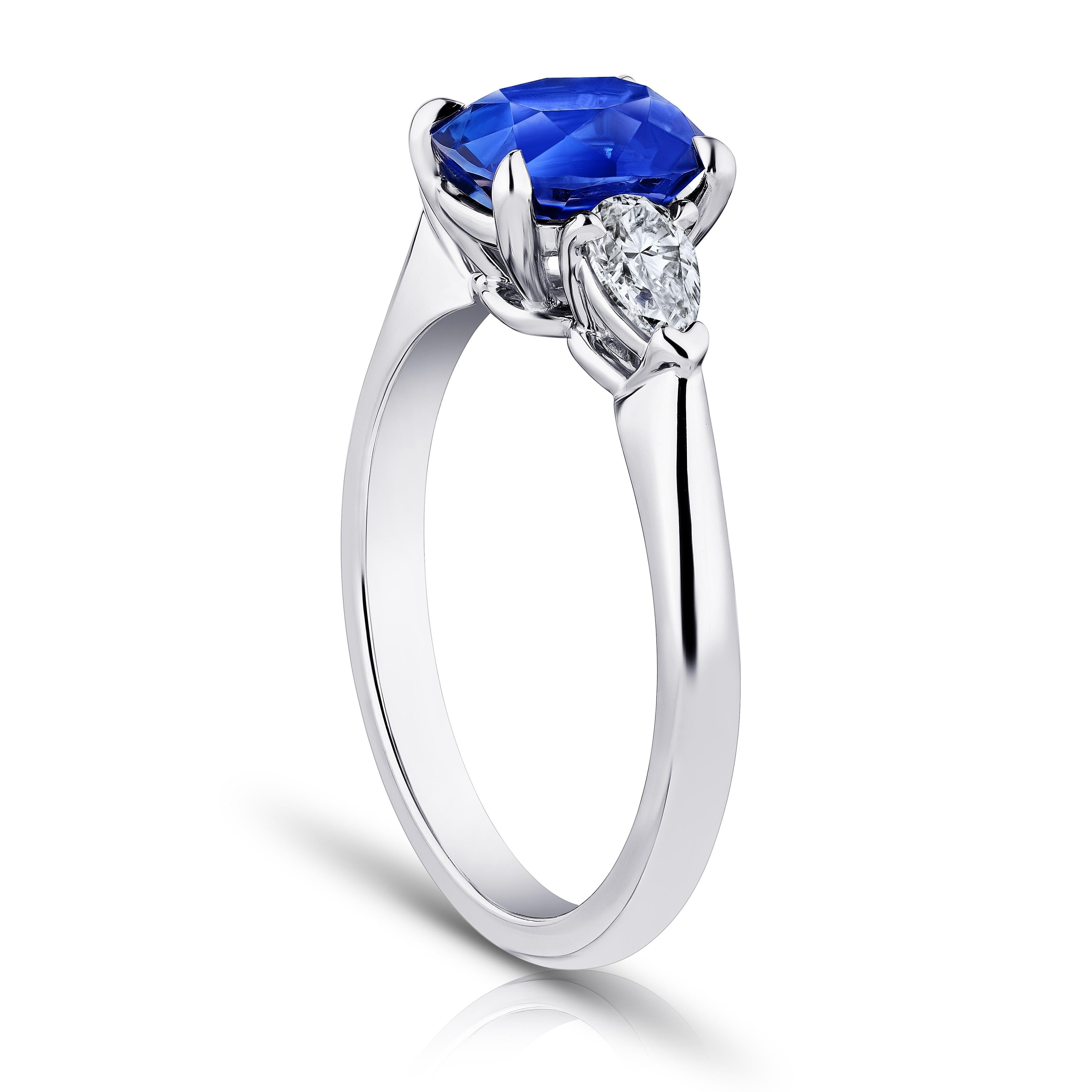 2.11 Karat kissenförmiger blauer Saphir mit birnenförmigen Diamanten von 0,49 Karat in einem Platinring gefasst. Größe 7.