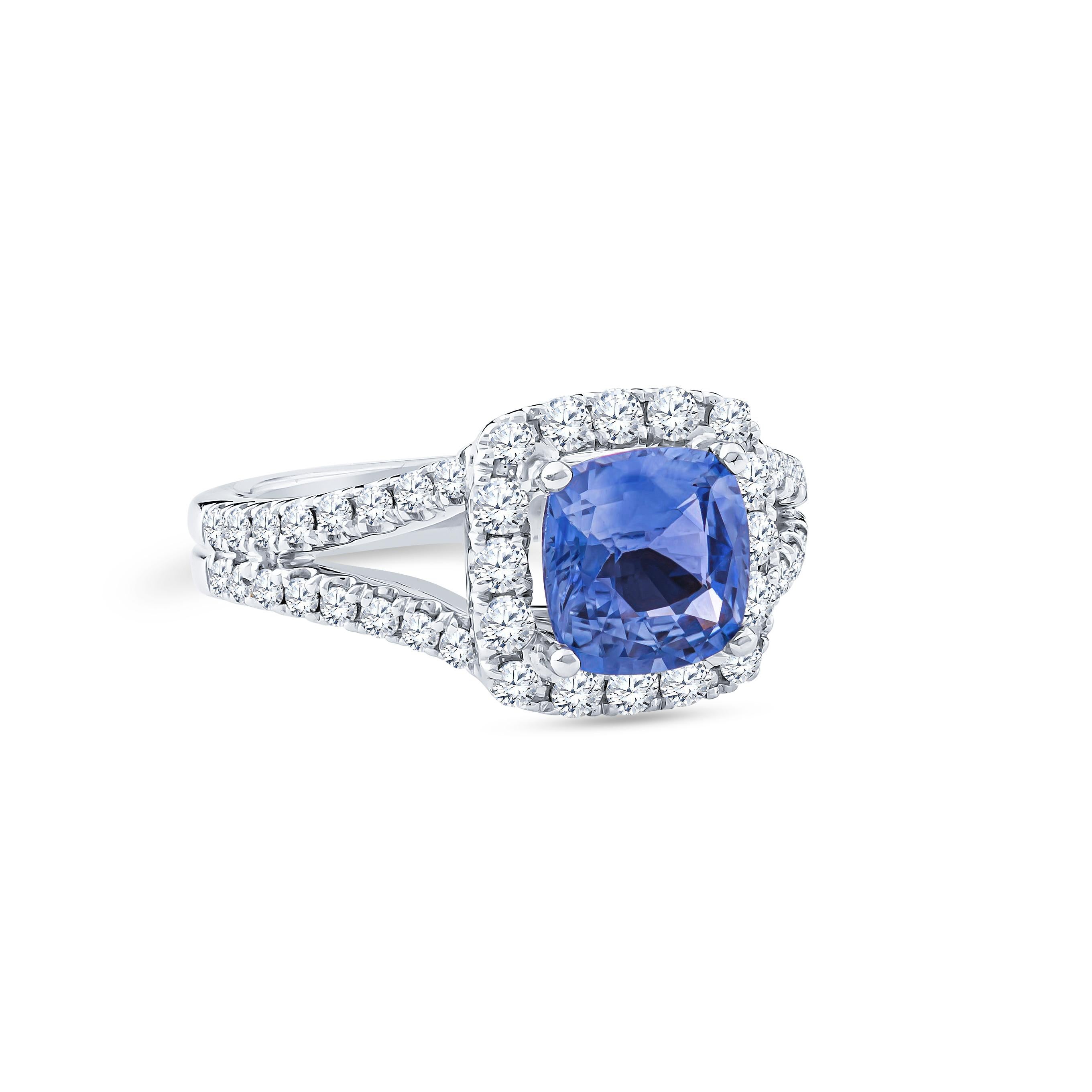 2.11 Carat cushion cut natural heated blue sapphire from Sri Lanka with 0.58 carat total weight round brilliant cut diamonds set in halo split shank form. Designed in 18K white gold sized to 6.5 and may be resized upon request.  

Diamond Quality