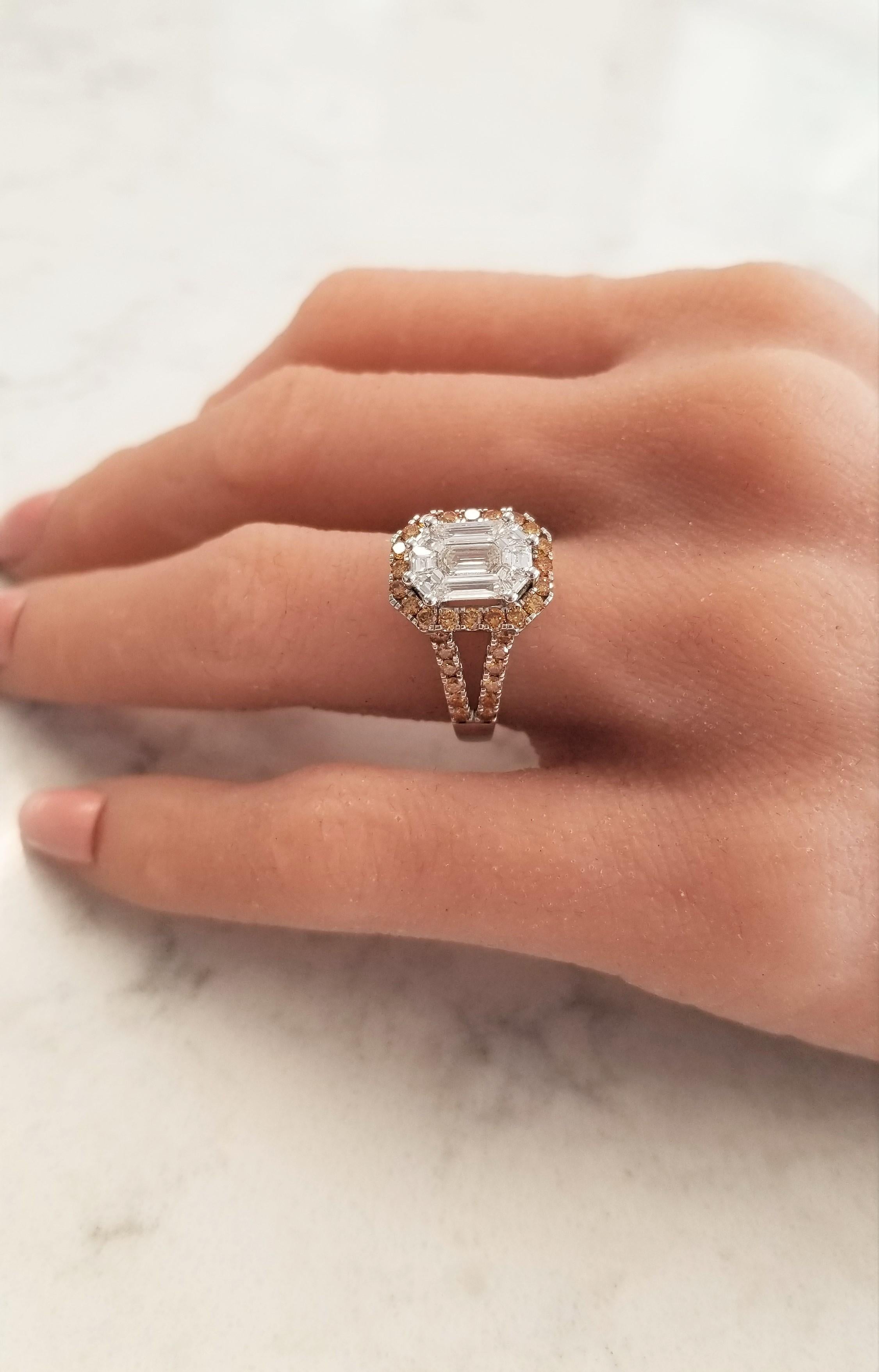 This is an illusion set ring. An emerald cut diamond is double prong set in the center, 9 step-cut trapezoid diamonds surround the emerald cut totaling for 2.11 carats. Together, the white diamonds measure 10.14x7.44mm. 1.10 carats of round