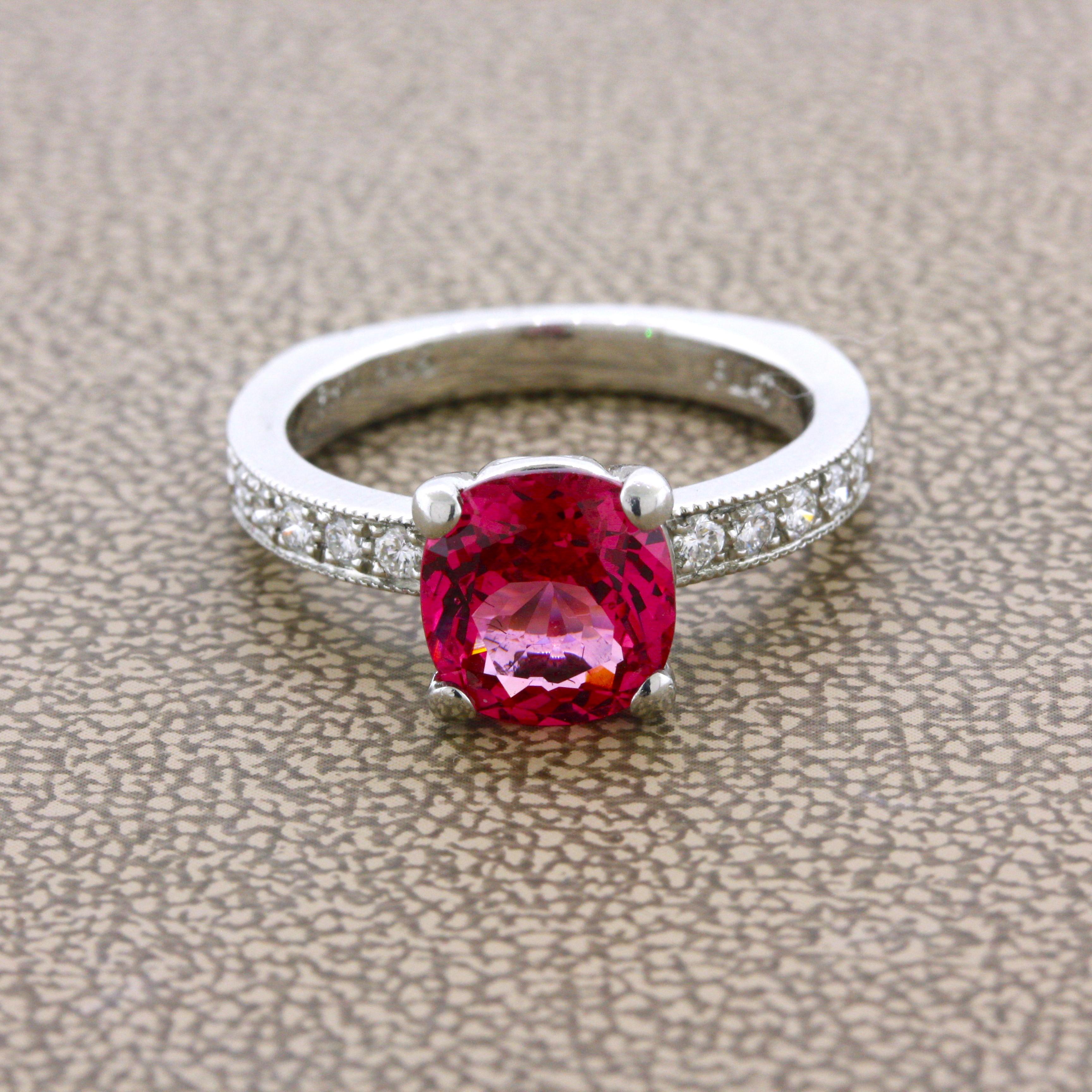 A fine gem spinel weighing 2.11 carats takes center stage! It has a bright intense red-pink color that is full of sparkle and brilliance. It is certified by the GIA as natural with no treatment and coming from Tanzania which is a strong source of