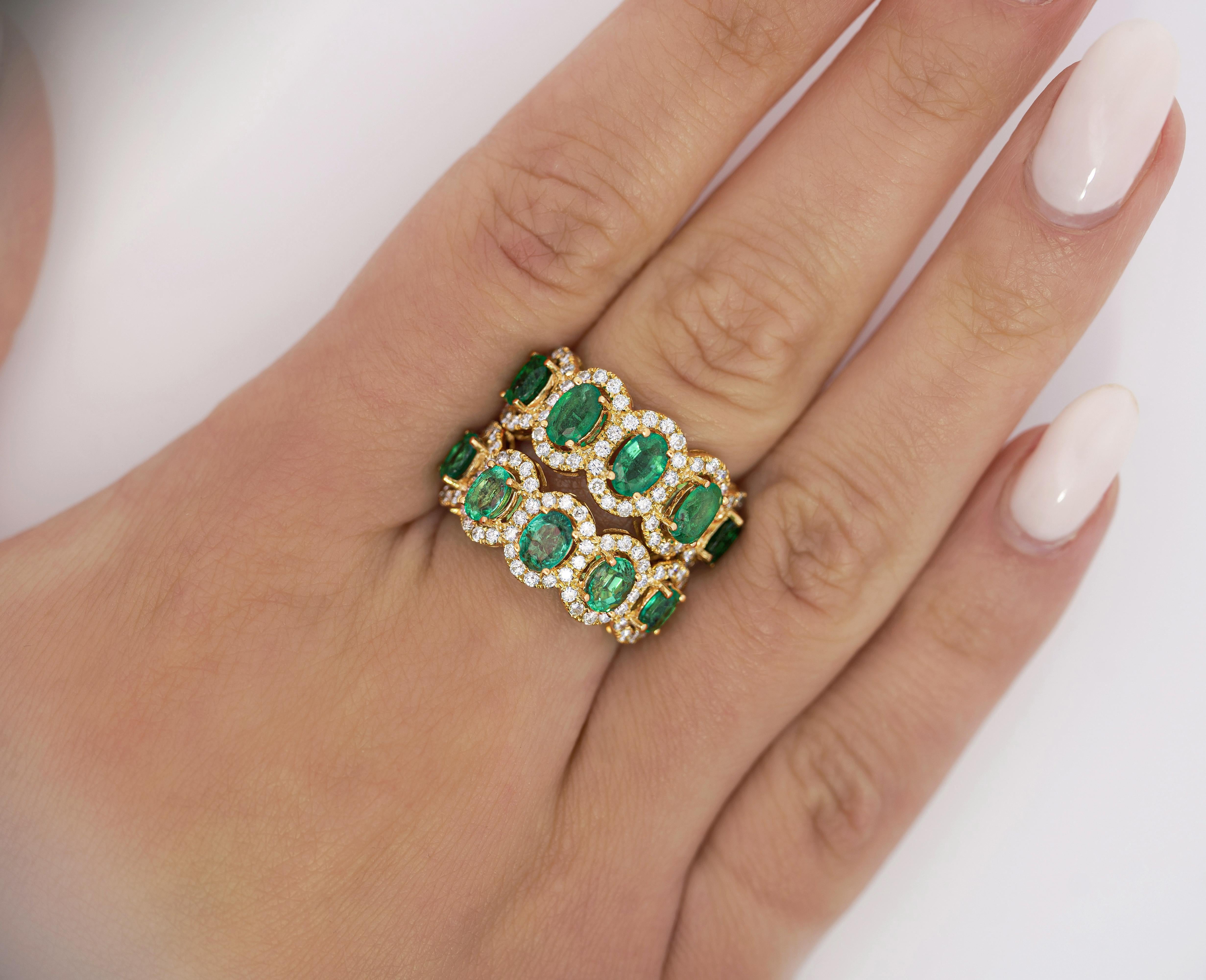 Natural Emerald and Diamond Wedding Band in 18k Solid Yellow Gold. 

This wedding band contains 5 emerald stones. Each stone is oval-cut and they carry a total weight of 1.53 carats. Each emerald is adorned with a round cut white diamond halo,