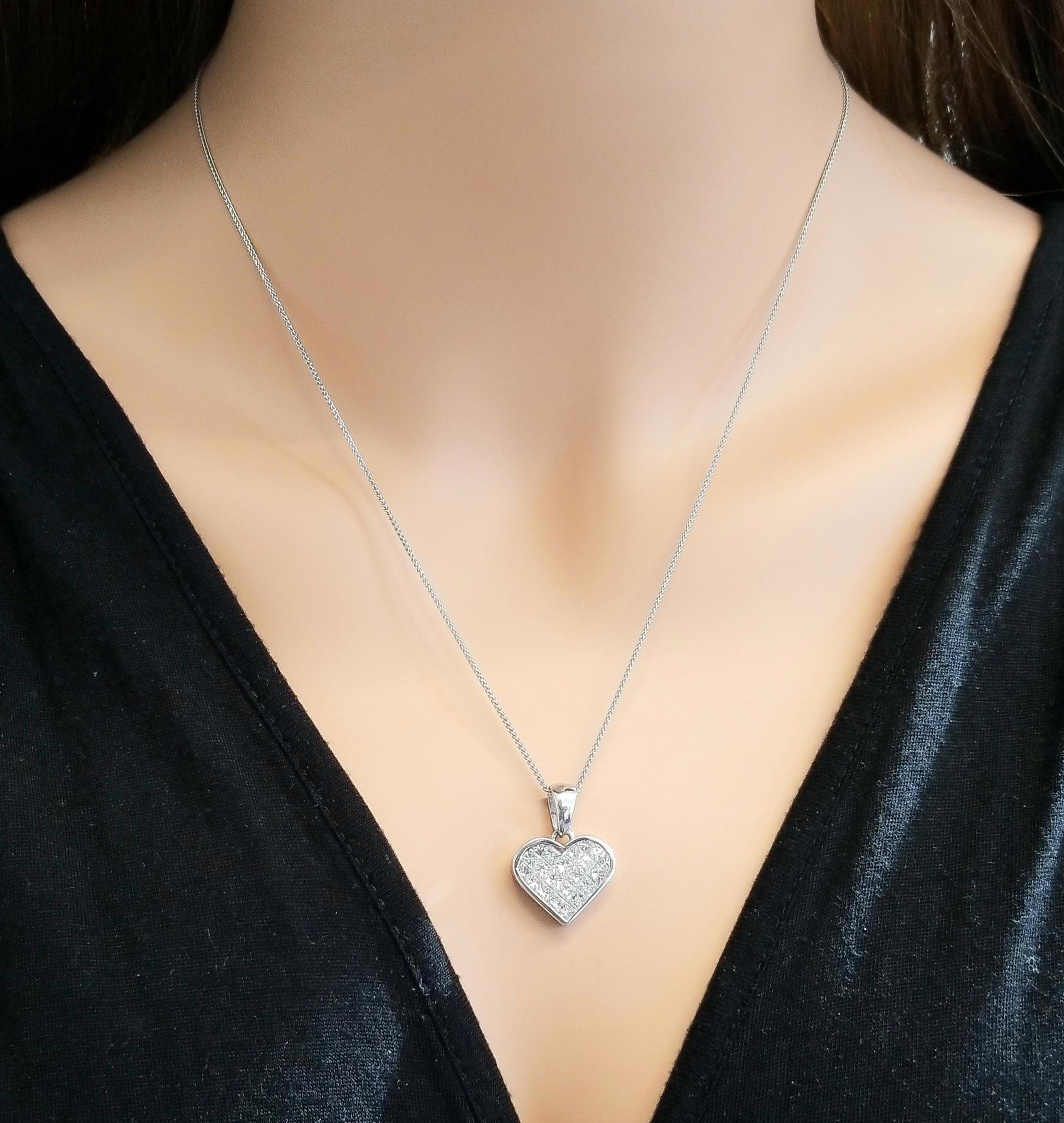 This gorgeous diamond heart pendant is invisibly set in 18K white gold. It features a sparkling collection of invisible set F-G color and VS2 clarity princess cut diamonds that fill up the center. The total diamond weight of this piece is 2.11 carat