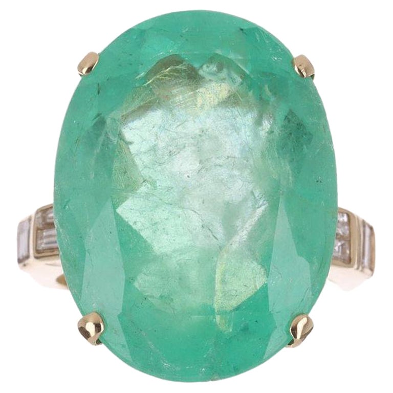 Guarda! Questo splendido anello da cocktail con smeraldo e diamante. La pietra centrale contiene ben 20,74 carati di pura bellezza di smeraldo colombiano. Tagliato a forma di ovale e proveniente direttamente dalle miniere di Muzo della Colombia. Su