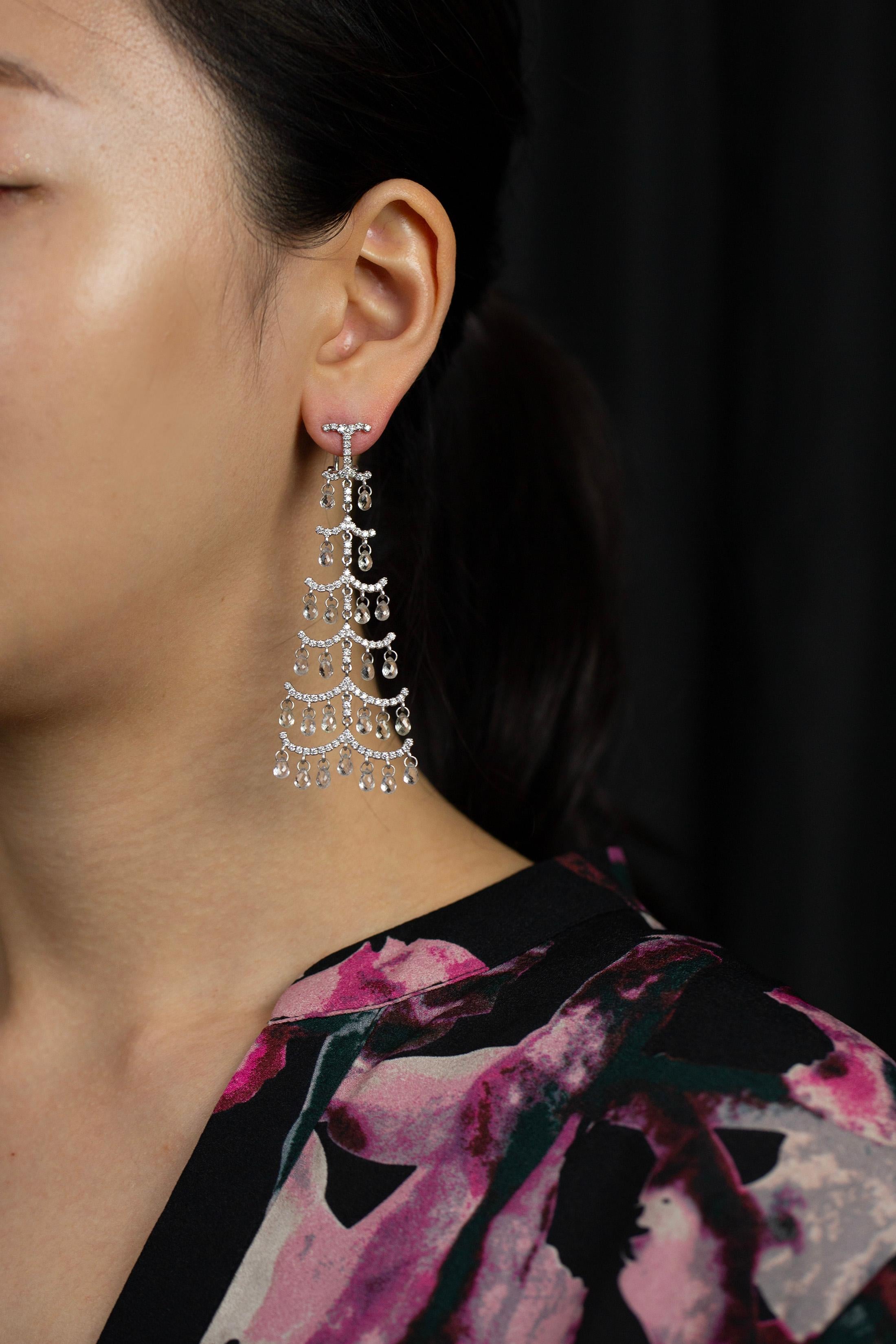 Une paire de boucles d'oreilles chandelier à la mode mettant en valeur des saphirs taillés en briolette, sertis dans 6 rangées de barres incrustées de diamants en or blanc 18k. Les saphirs pèsent 19,00 carats au total ; les diamants pèsent 2,17