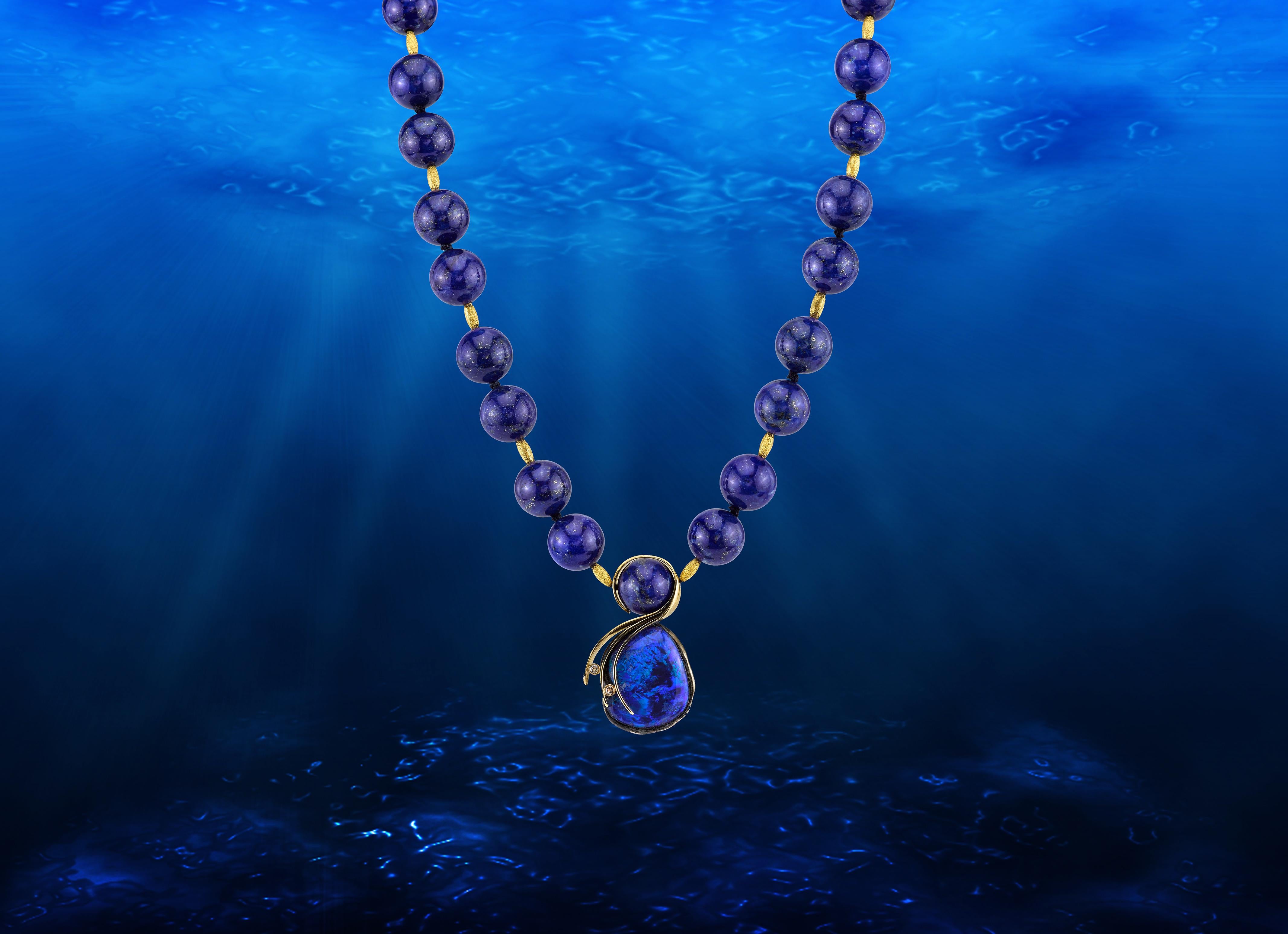 This stunning necklace is a true masterpiece that captures the essence of the deep blue Mediterranean and the golden sands of the shore. The centerpiece of the necklace is a magnificent 21.18 CT Lightning Ridge Opal, hanging from an 18 Karat Yellow