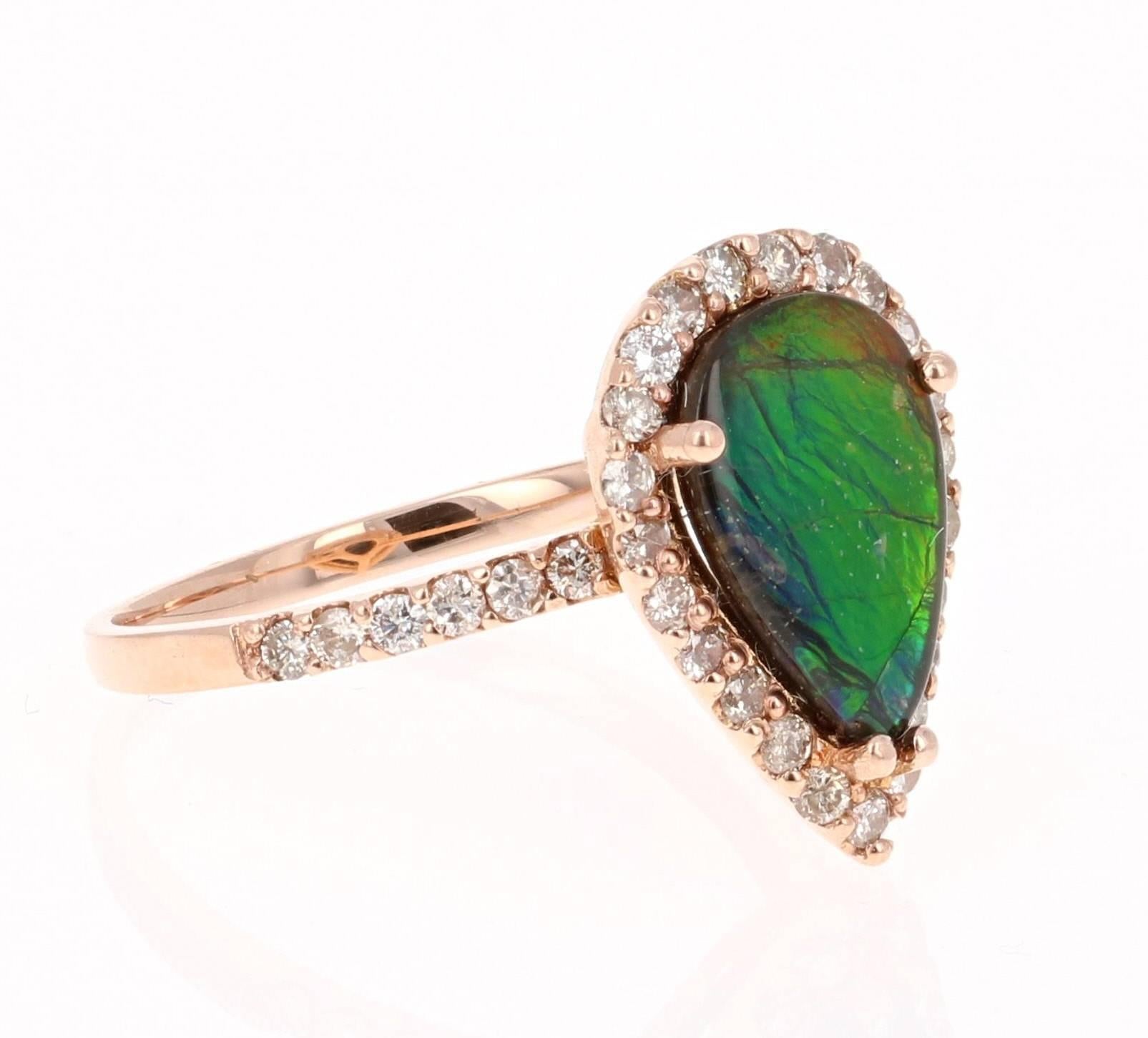 This unique ring has a 1.56 Carat Pear Cut Ammolite in the center of the ring.  Ammolite is an Opal-like organic gemstone that is primarily found in the eastern slopes of the North American Rocky Mountains. The Ammolite has hues of green, blue, and