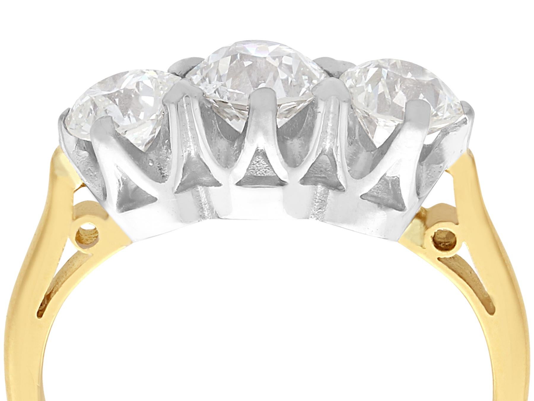 A stunning, fine and impressive antique 2.12 carat diamond three stone ring displayed in a contemporary 18 karat yellow gold and 18 karat white gold setting; part of our diamond jewellery and estate jewelry collections.

This stunning three stone
