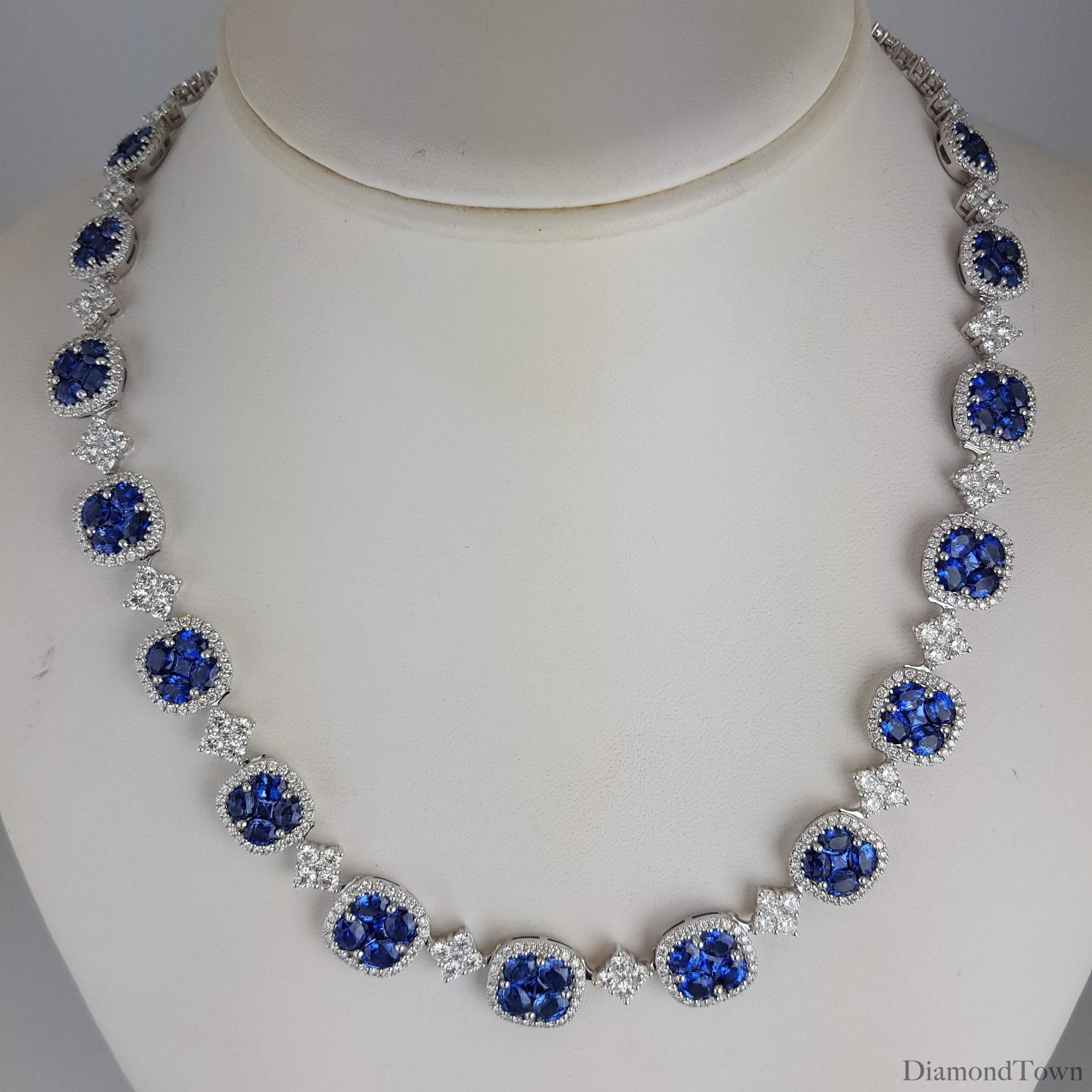(DiamondTown) This impressive necklace features fifteen blue sapphire clusters, each inside a halo of round diamonds, and alternating with square clusters of round white diamonds. Additional diamond clusters extend to the back of the necklace.

Each
