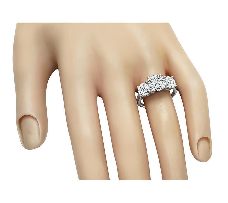 This is a gorgeous platinum engagement ring. The ring is centered with sparkling round cut diamond that weighs approximately 2.12ct. The color of the diamond is G-H with SI1 clarity. The center diamond is accentuated by two dazzling round cut