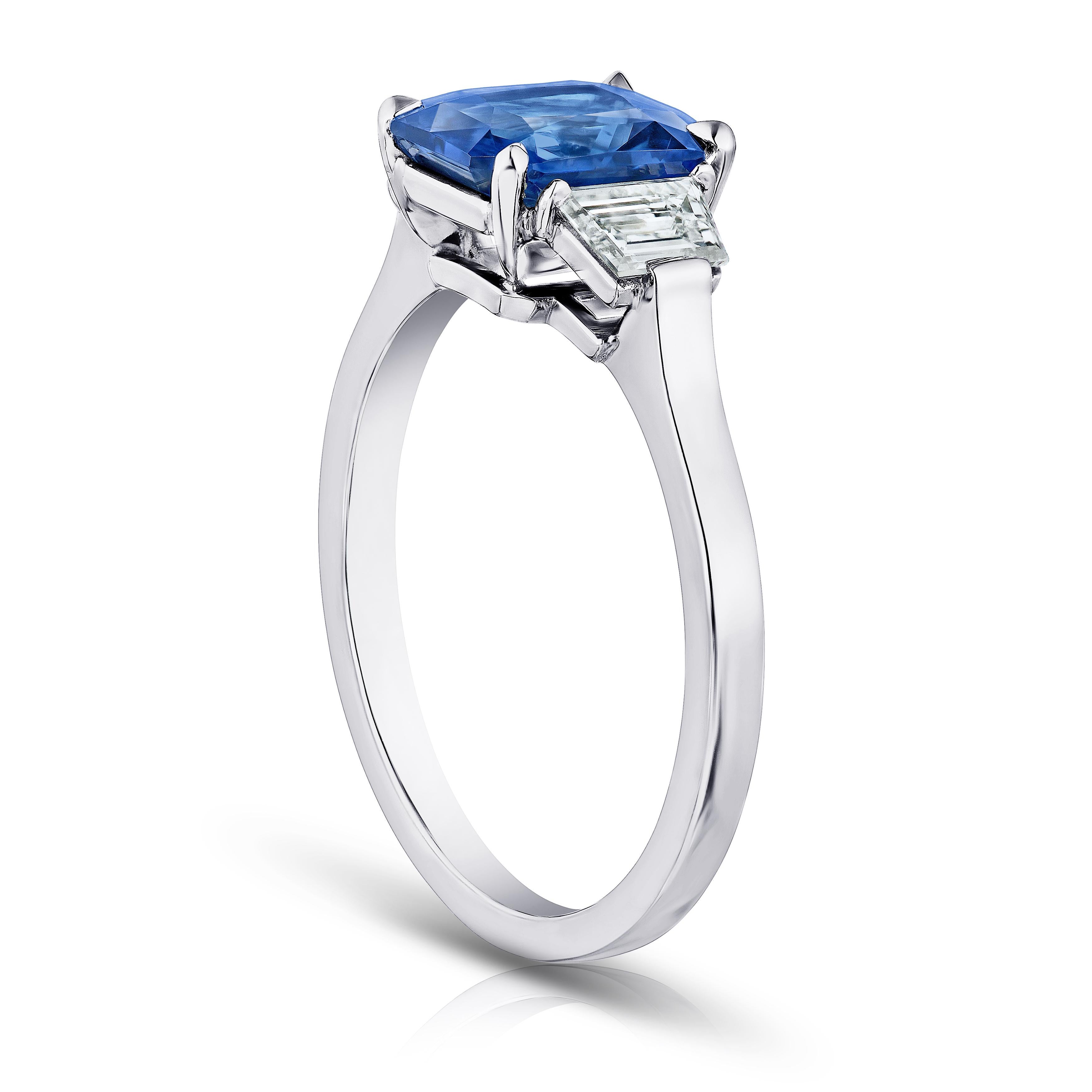 2.13 carat radiant cut blue sapphire with trapezoid step cut diamonds .47 carats set in a platinum ring. This ring is currently a size 7.  We will resize to your finger size without charge.
