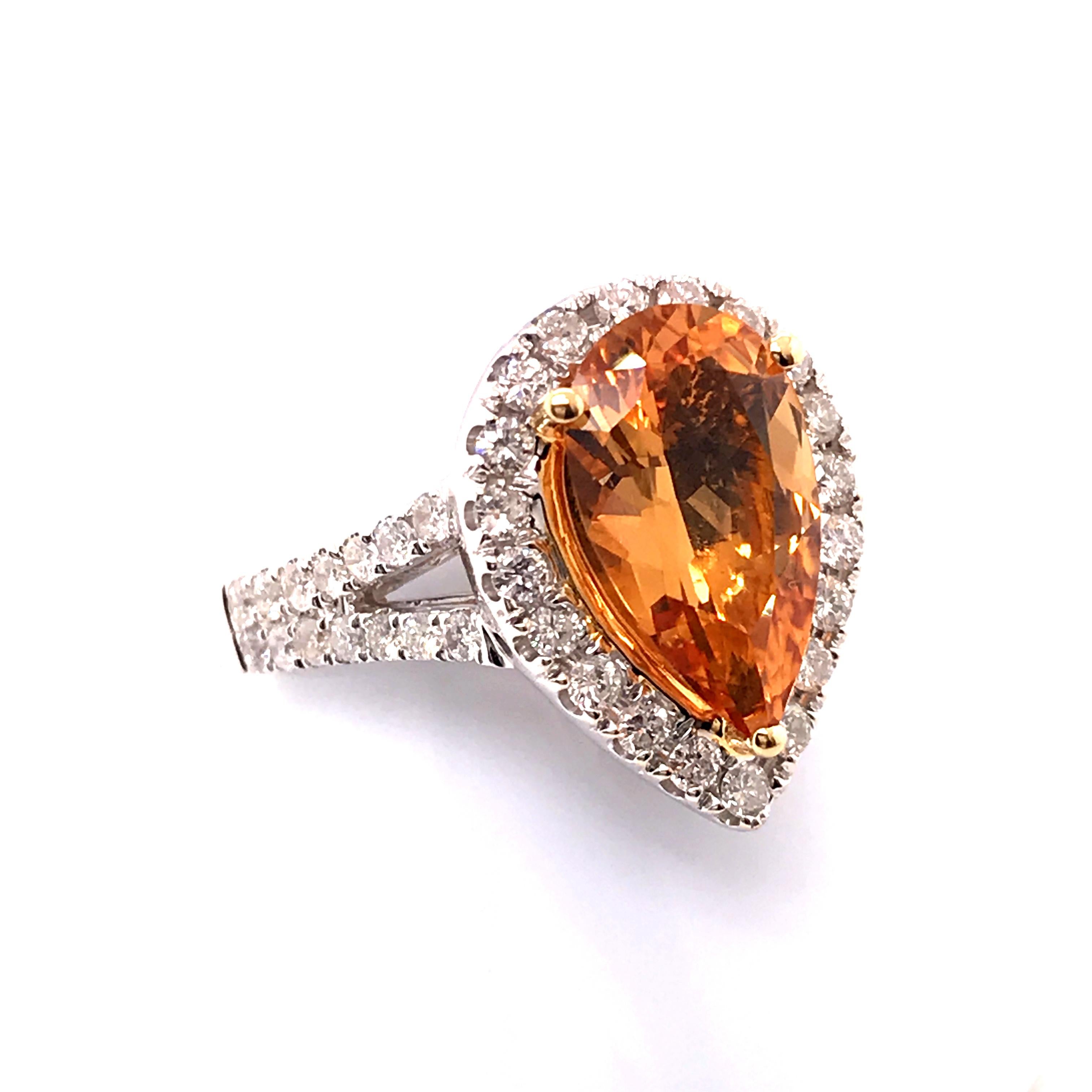 This is an 18-karat two-tone gold ring mostly white gold with a yellow gold basket and prongs. The split shank has round diamonds that balance out the pear shape center stone perfectly which is surrounded by additional round diamonds. In total, the