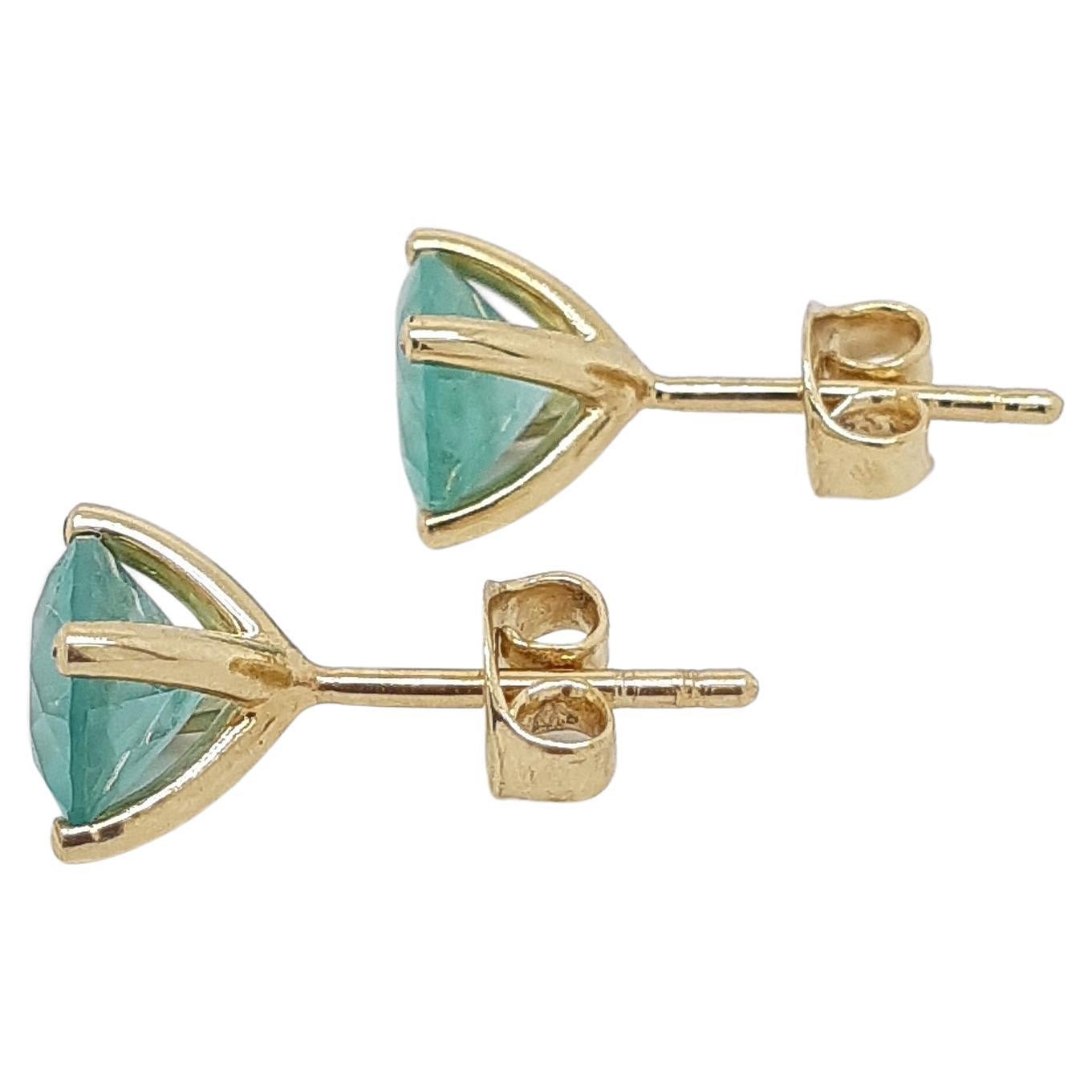 FOR U.S. BUYERS NO VAT 

If you want to add color to any style you chose, these 14kt yellow emerald stud earrings weighing 2.11 grams are definitely for you. These gorgeous earrings feature two round brilliant cut bluish green emeralds set in 14kt