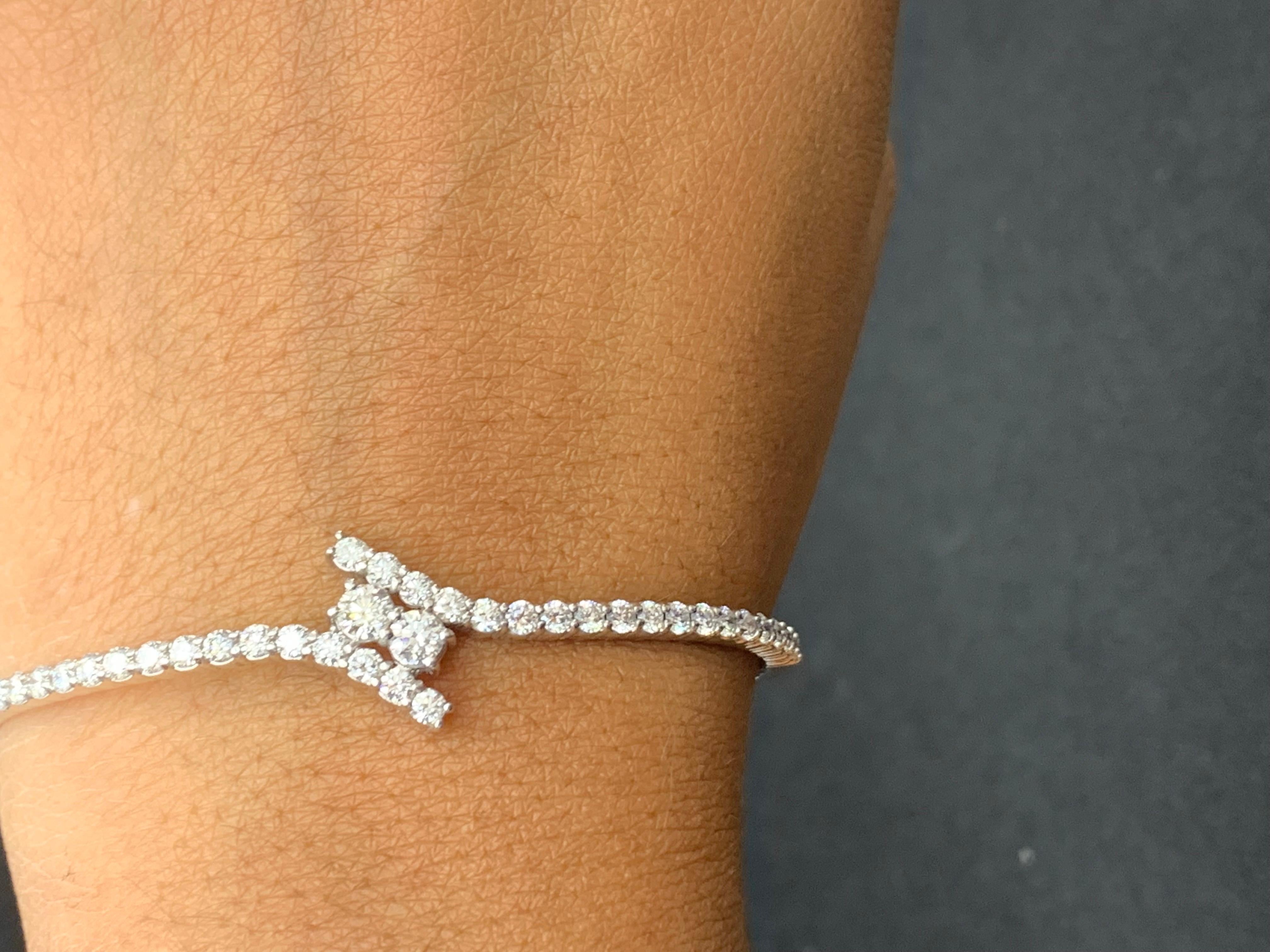 Ce magnifique bracelet présente 40 diamants ronds et brillants pesant 2,13 carats au total. Le bangle a un design incurvé avec 2 diamants sertis au centre. Fabriqué en or blanc 14 carats.
