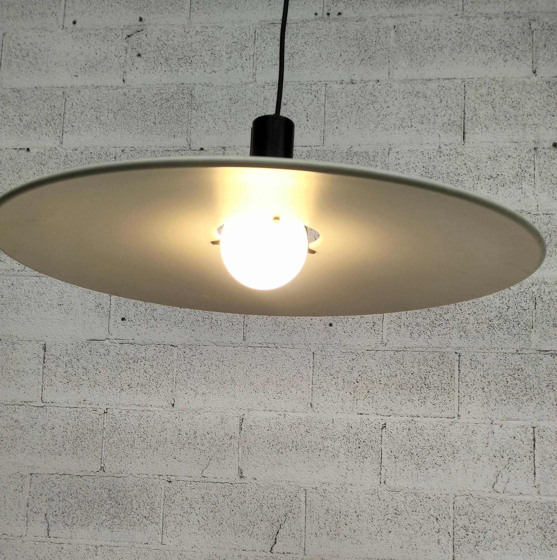 Lampada a sospensione lampadario in metallo modello 2133 disegnata da Gino Sarfatti e prodotta da Arteluce Italia anni Settanta.
Paralume in metallo bianco con portalampada in metallo nero, dove il paralume rimane attaccato. Marchio presente nella