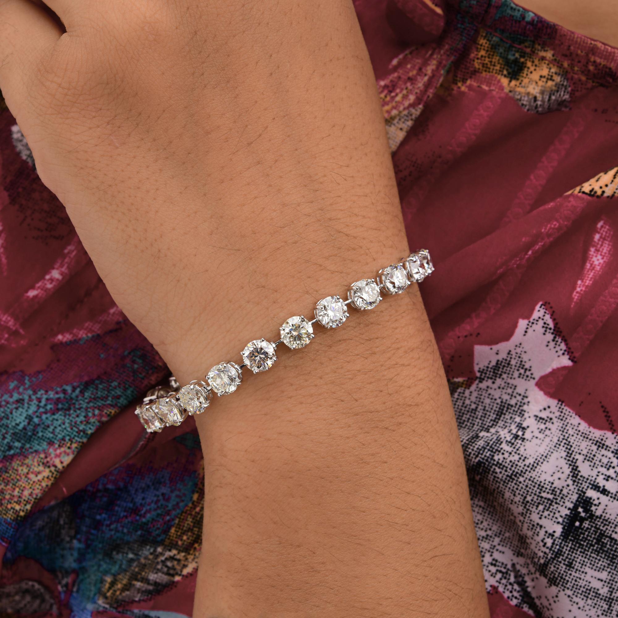 Esta pulsera de tenis de oro blanco de 18 quilates con diamantes redondos talla brillante SI/H de 21,35 quilates presenta diamantes redondos engastados en hilera formando una pulsera de tenis. 
Los diamantes son un símbolo universal de eternidad y