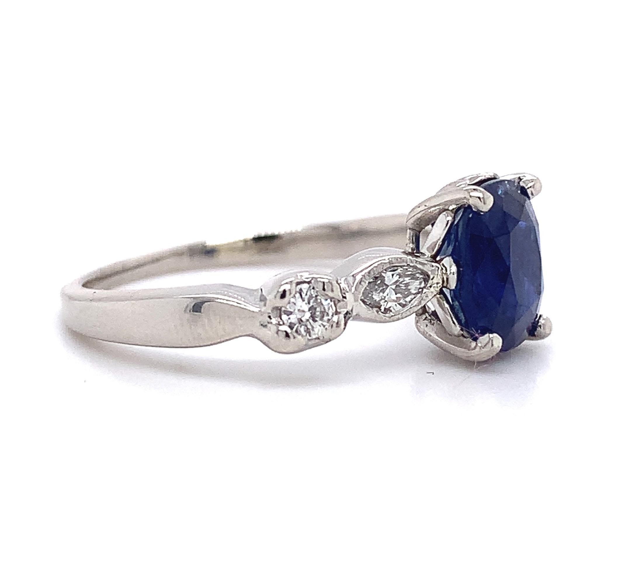 Platinum blue sapphire and diamond ring featuring a rectangular cushion cut sapphire weighing 2.13 carats. The genuine earth mined sapphire has royal blue color. It measures about 7.8mm x 6.6mm. The sapphire is accented by 2 marquise diamonds and 2