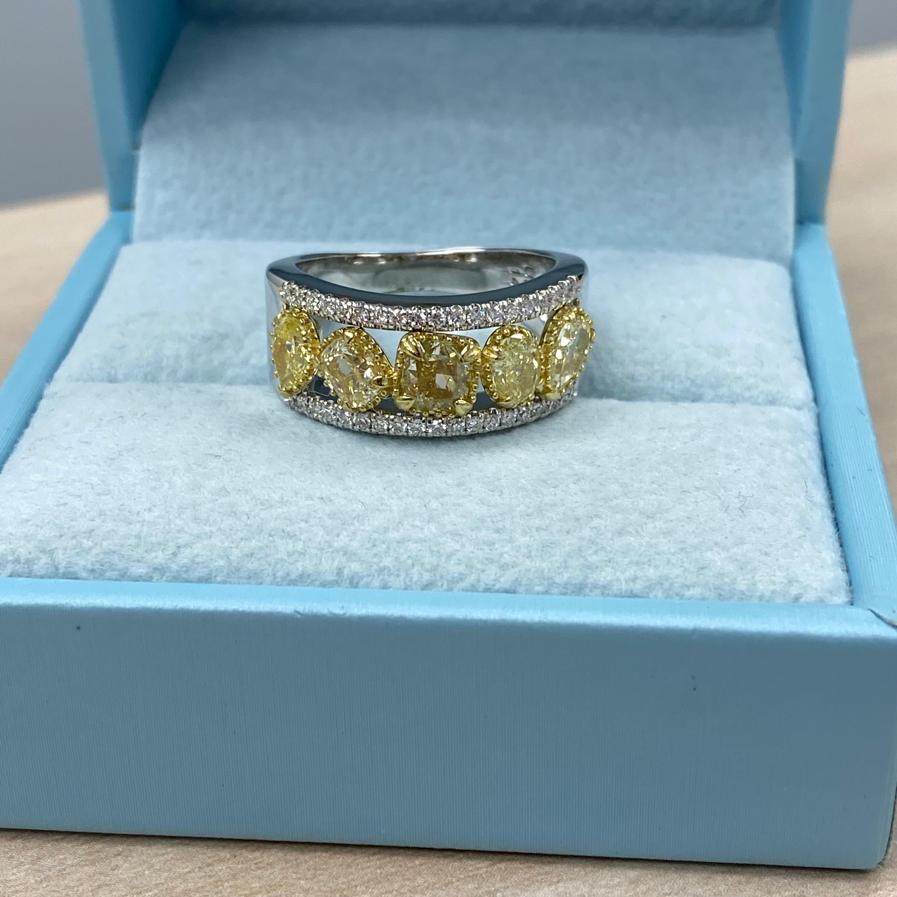 Cette bague de mariage exquise met en valeur un superbe ensemble de 1,81 carat de diamants de forme multiple de couleur jaune clair fantaisie et de pureté SI/I, joliment nichés entre des rangées de diamants blancs totalisant 0,33 carat, de couleur