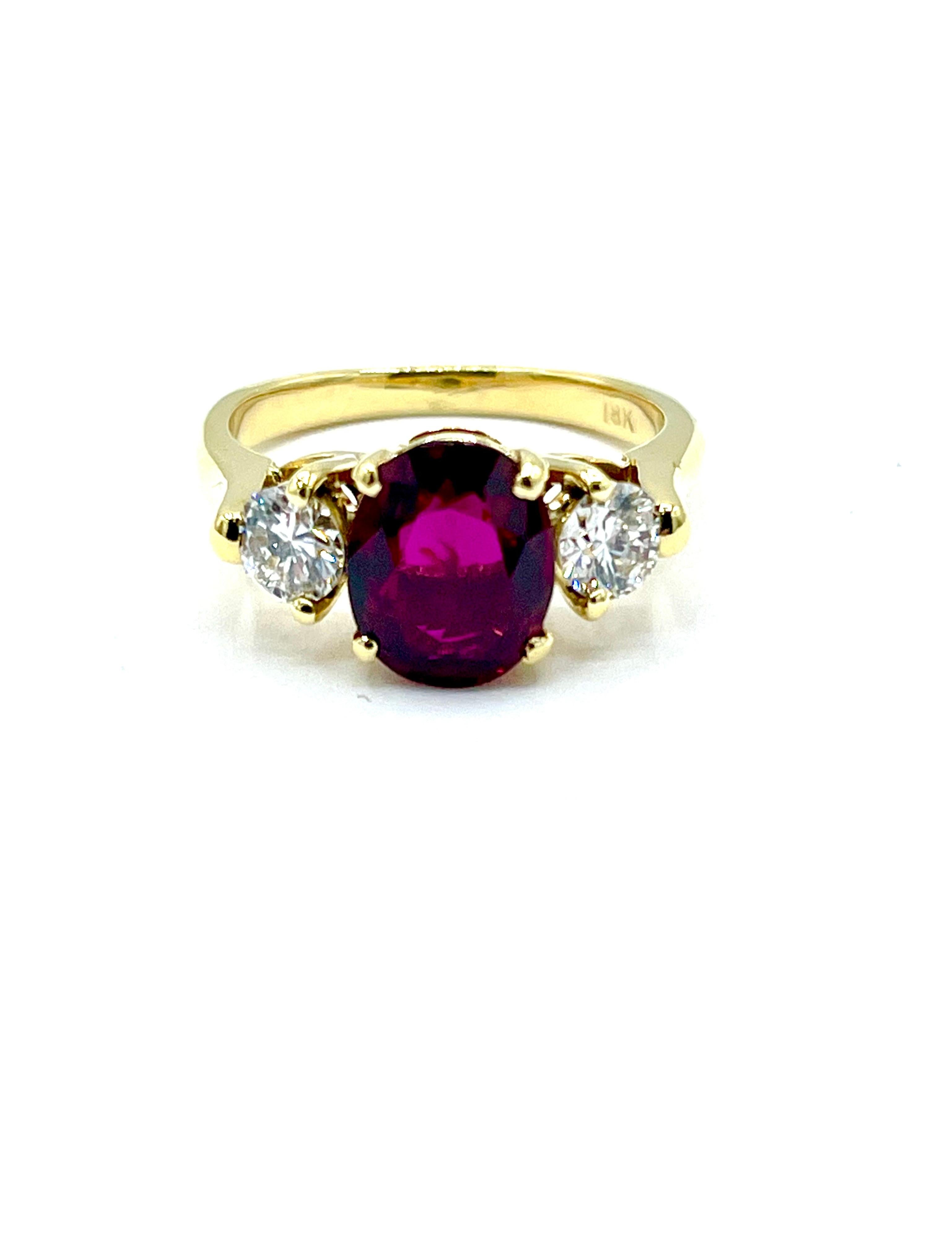 A gorgeous Ruby and Diamond ring!  The 2.14 carat crimson red Ruby is set in a four prong basket mounting, with a single round brilliant Diamond on each side.  The shoulders of the shank come up from the shank to act as the outside third prong.  The