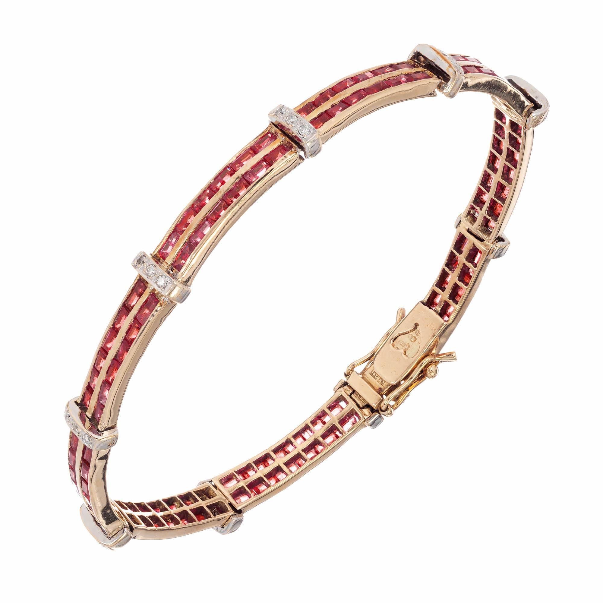 14k yellow gold ruby and diamond bracelet. Double row of ruby baguettes are channel set in a link with a cross bar of pave set round diamonds in white gold separating links.

108 straight step cut baguette rubies Approximate 2.00 carats 
27 round