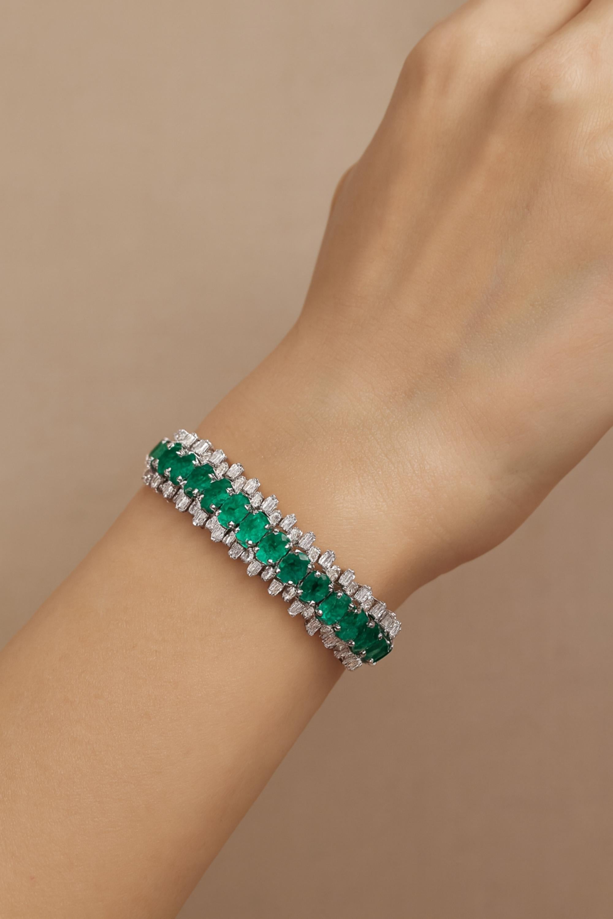 Dieses breite Armband aus 18 Karat Weißgold mit 21,42 Karat Smaragd und 8,97 Karat SI/H-Diamanten verfügt über eine dreifache Reihe oval geschliffener Smaragde in der Mitte des Armbands und Diamanten am oberen und unteren Ende des Armbands, wodurch