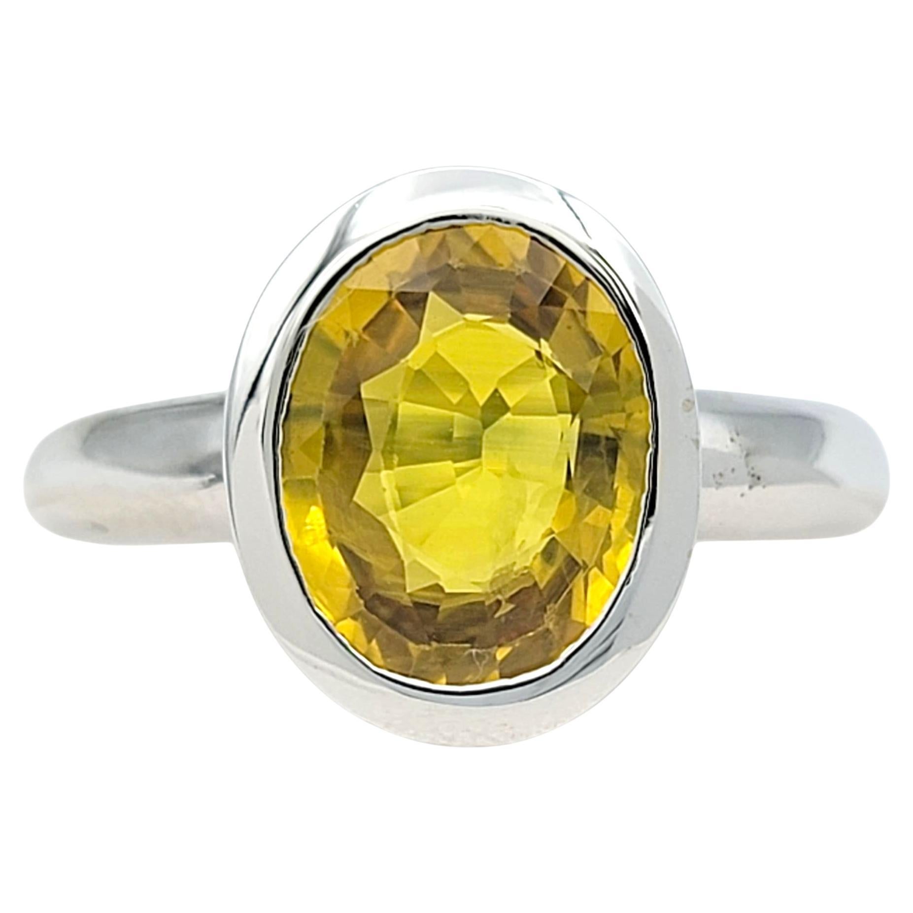 Rayonnant d'un éclat doré, cette exquise bague en saphir jaune capture la chaleur et l'éclat dans une silhouette intemporelle. Le saphir de taille ovale est serti dans un élégant or blanc 18 carats, permettant à la pierre précieuse vibrante