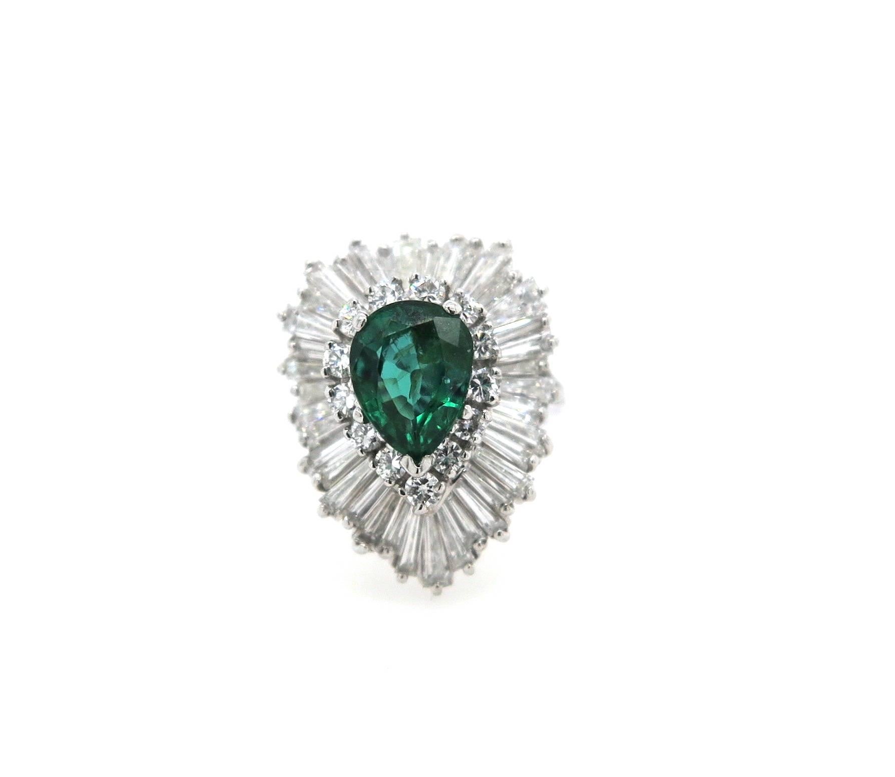 Featuring a modern platinum dress ring claw set with a central pear shaped Colombian Emerald of 2.15 carats surrounded in two tiers with 13 Round Brilliant Cut Diamonds and 38 Tapered Baguette cut diamonds. The ring has a rounded shank of 2.2mm