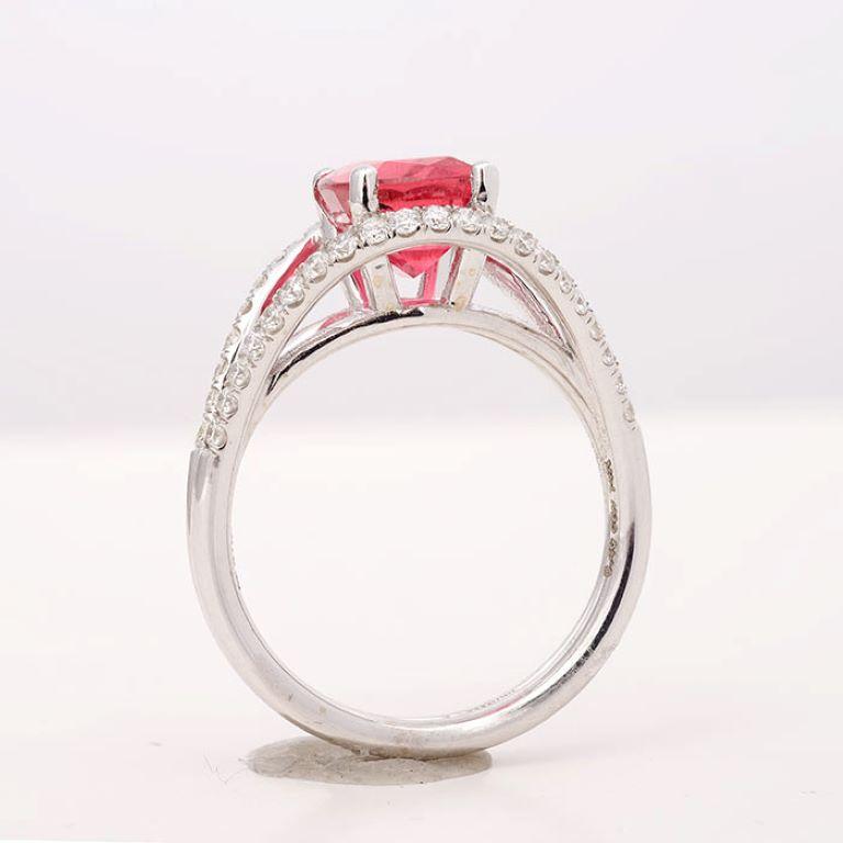 Mit einem elektrischen 2,15 Karat, rosa Turmalin in der Mitte des Rings wird es sicherlich Ihren Hautton zu betonen. Mit kräftigen Zacken aus 14-karätigem Weißgold gefasst, scheint der zentrale Stein in einer Umrandung aus Diamanten zu
