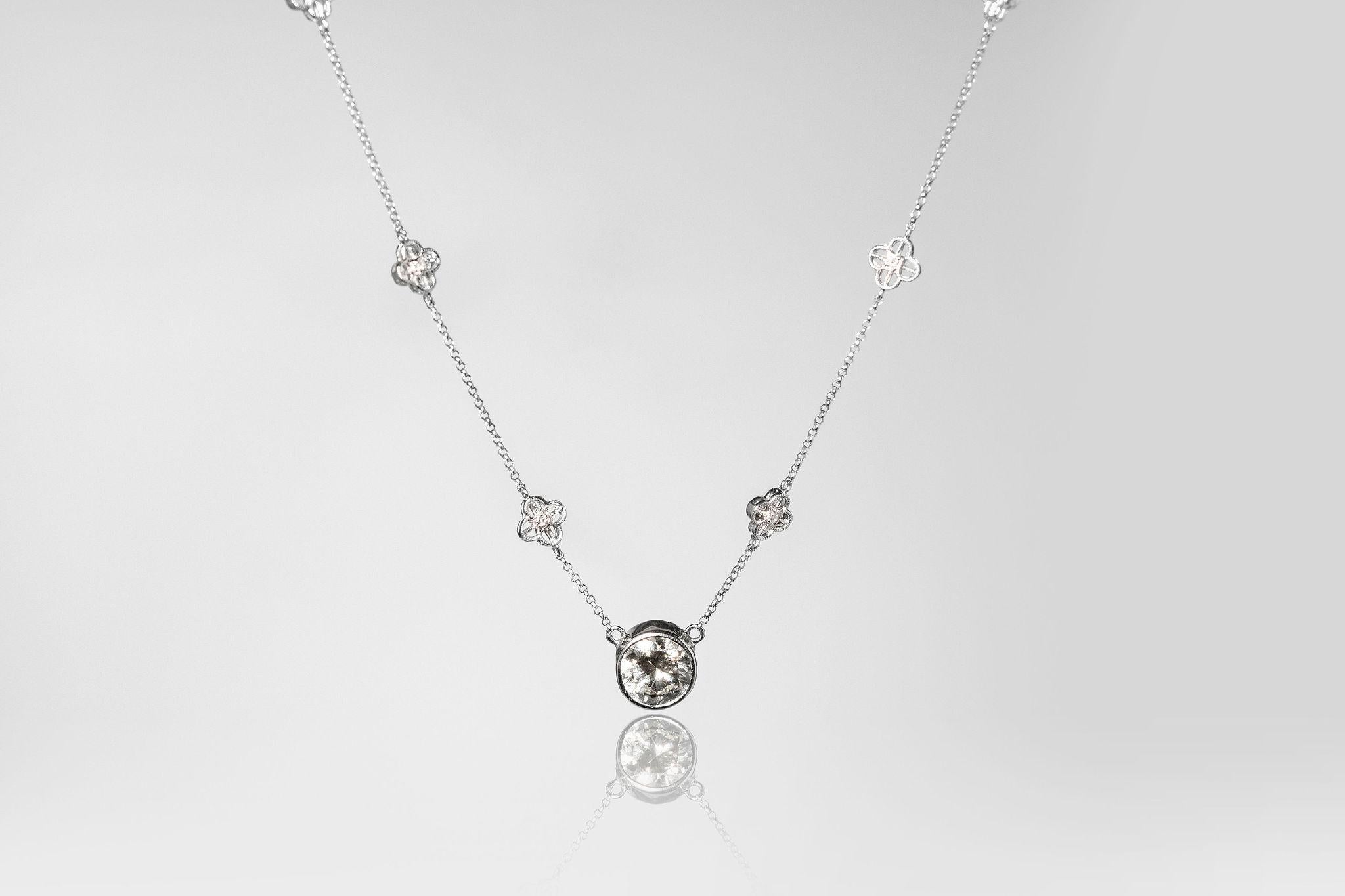 Magnificent 2.15ct centre stone round diamond is set in a 18k white gold bezel. Handmade in Paris France. The diamond shines magnificently on this handmade chain making this necklace glamours.   The chain has 10 small flowers. Each flower has a