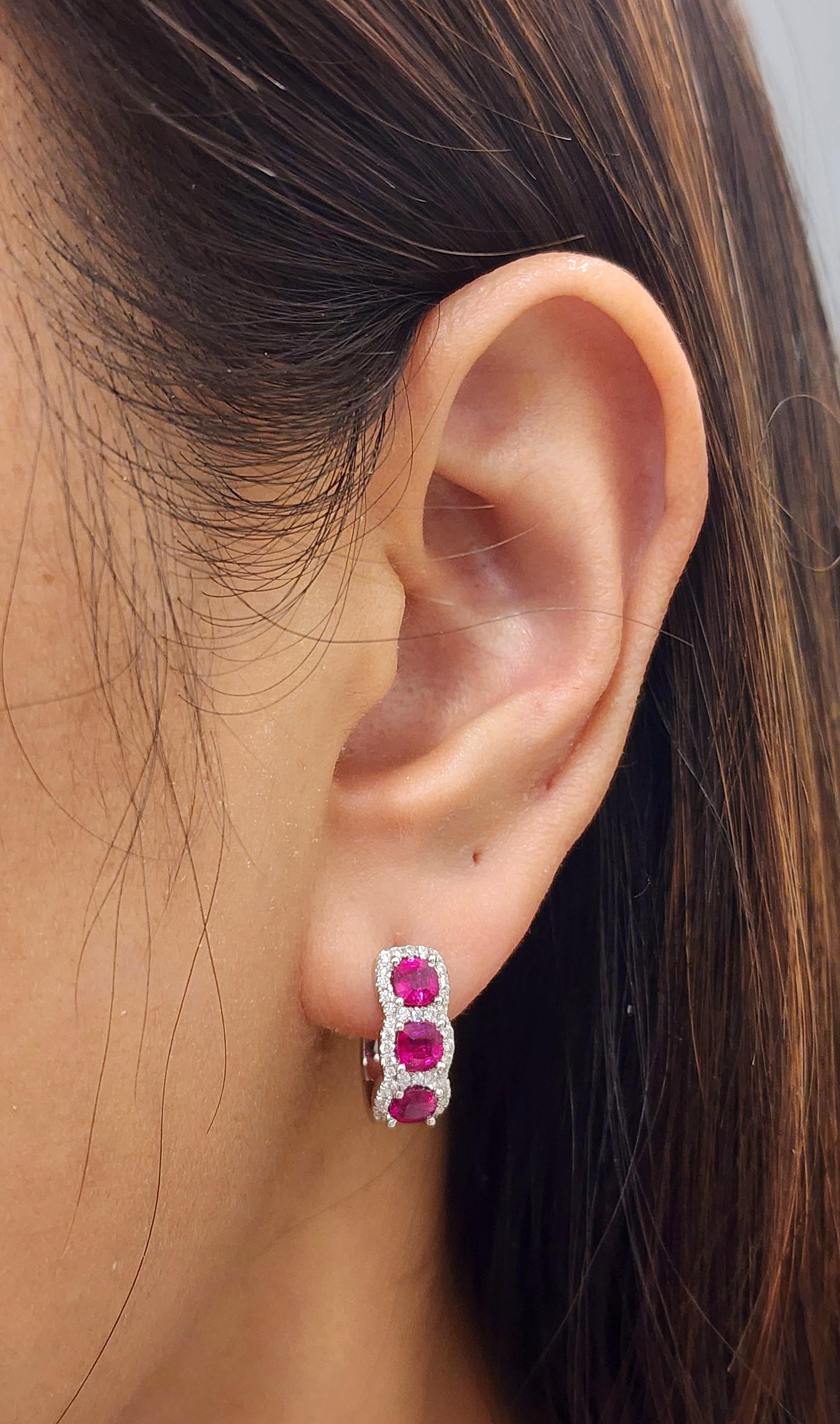 These stunning huggie earrings feature 6 rubies weighing 1.77 ct, accented by round diamonds weighing 0.38 ct. The rubies display a vibrant red hue, while the diamonds are white, with a clarity of VS2/SI1 and a color grade of G/H. Crafted in 18k