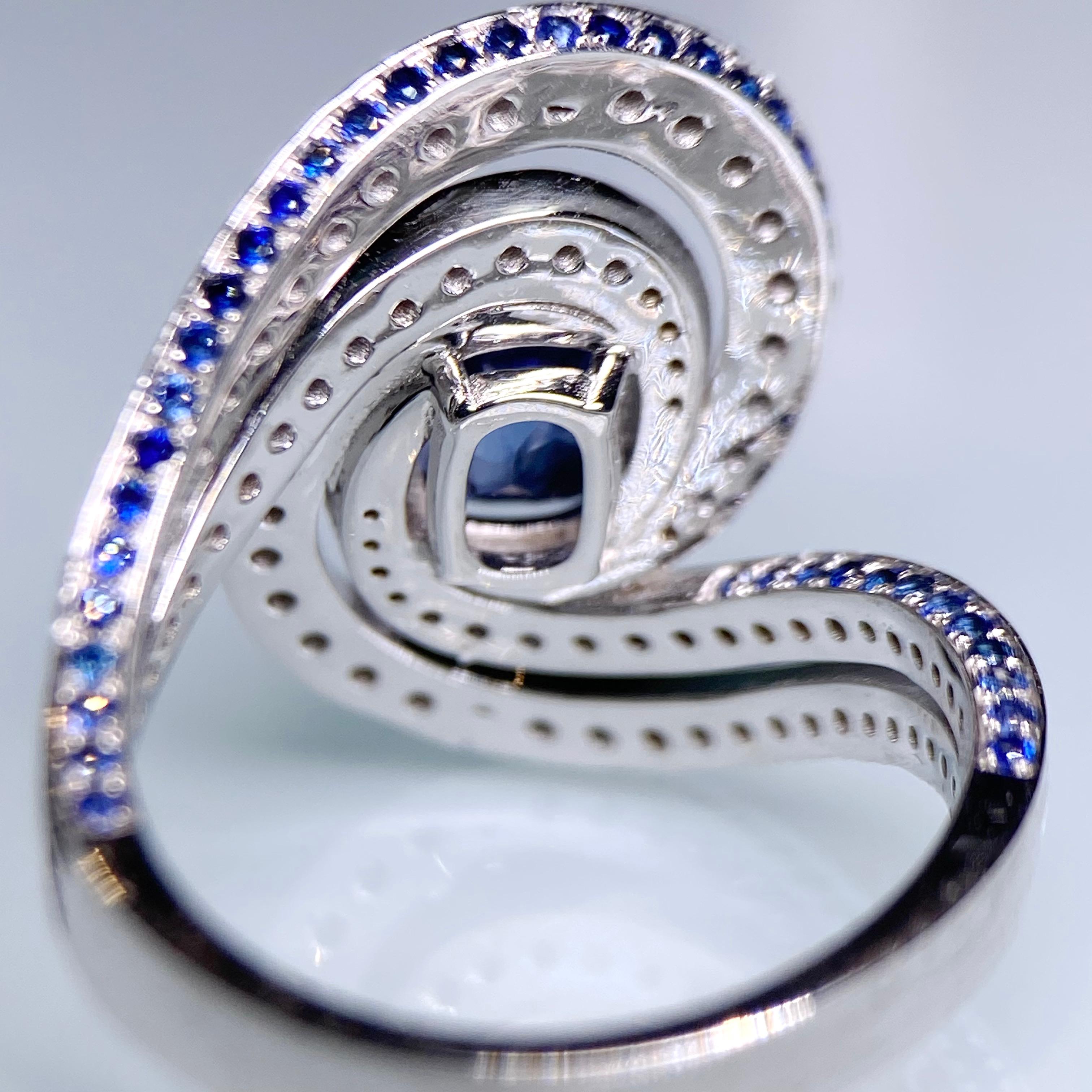 Another unique design with opened frame work. The Blue Sapphire is sitting on top of the spiral. Diamonds are encrusted on the horizontal of the spiral and on the other side of the spiral it is full of sapphire pave. Once again this setting allows