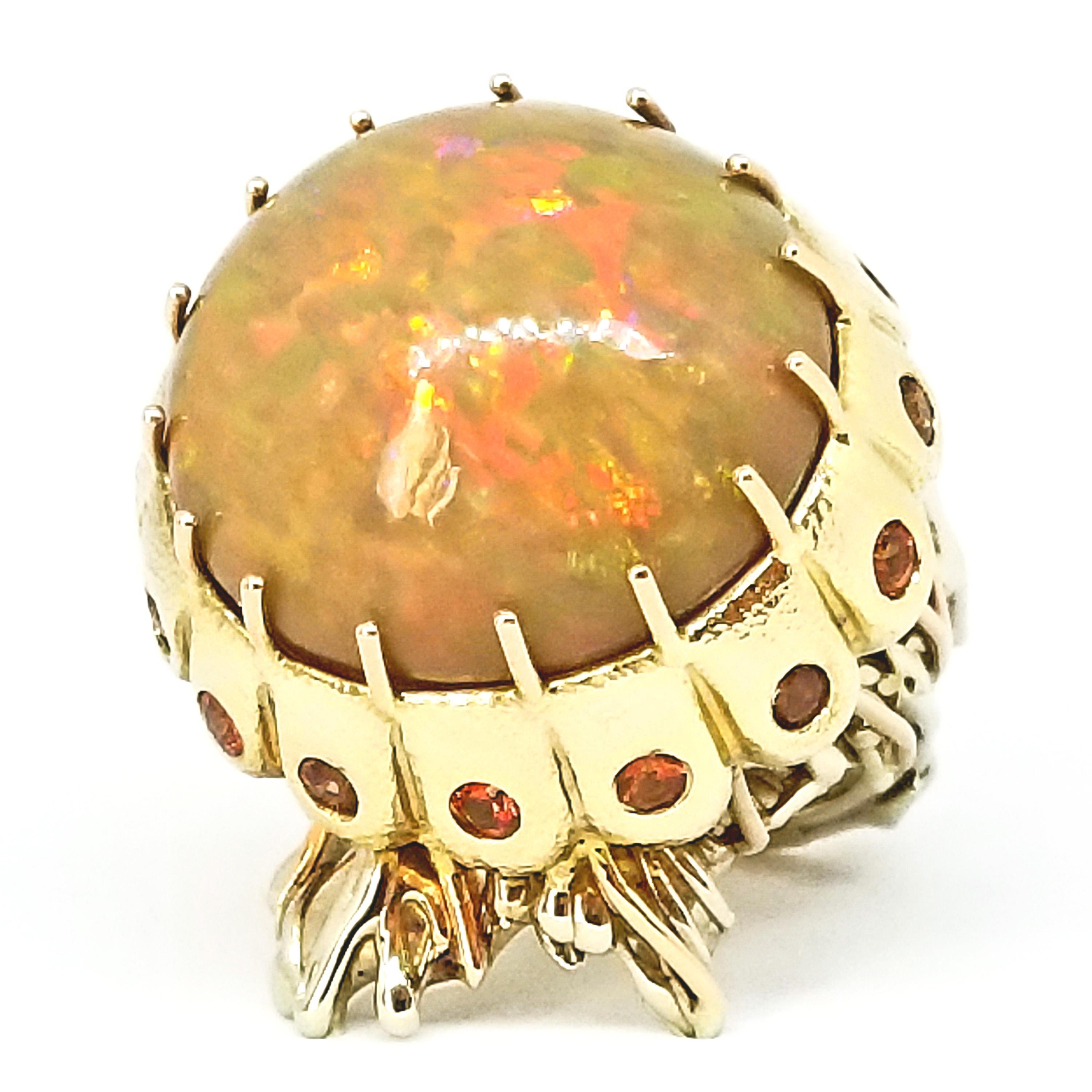 One of a Kind Statement Ring by American Artist-Designer Tom Castor features a Large, Solid, Natural Ethiopian Opal of 21.50 Carats. This Round, Dome cut Gem has Intense Fire and Color Play of AAA Quality. 
It is set in a Hand Crafted circle of