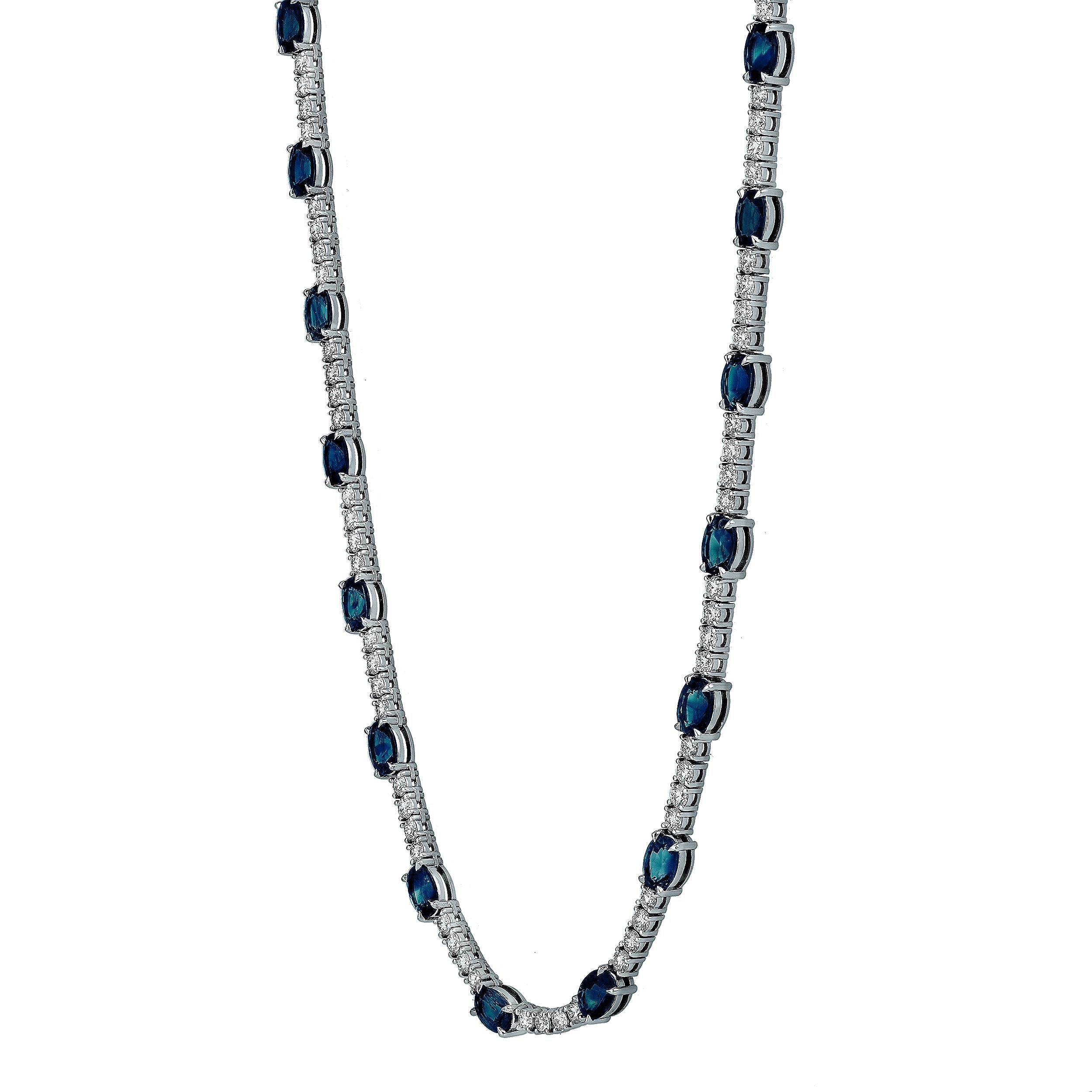 Impresionante collar tenis con zafiros azules ovalados, de un peso total de 21,59 quilates. Cada zafiro está espaciado uniformemente por diamantes redondos talla brillante. Los diamantes pesan 6,69 quilates en total. Finamente fabricada en oro