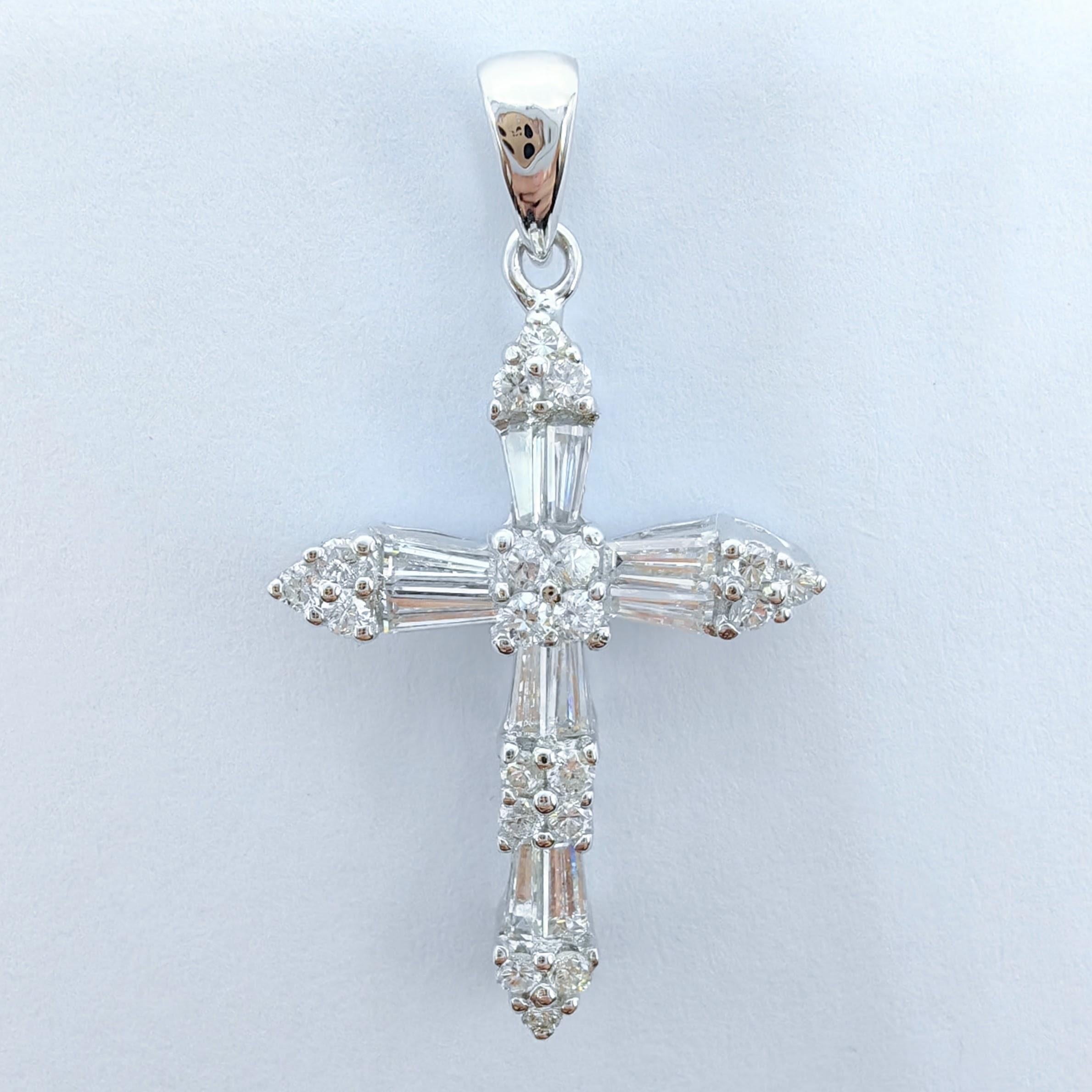 Voici notre pendentif croix classique en diamant taille baguette et ronde, un symbole intemporel de foi et d'élégance. Fabriqué en or blanc 18 carats, ce pendentif exquis présente un superbe arrangement de diamants qui accentuent magnifiquement le