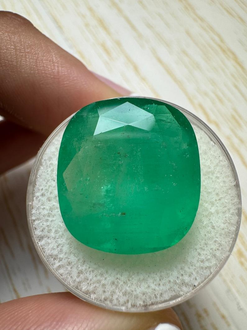 Stone: Emerald
Weight: 21.62-carats
Shape: Cushion Cut
Clarity: Semi-Transparent
Luster: Very Good
Color: Medium Green
Measurements: 18.64mm x 16.85mm x 9.77mm
Geographic Origin: Colombia
Treatment: Natural, Oiling

Comments: Due to their growth