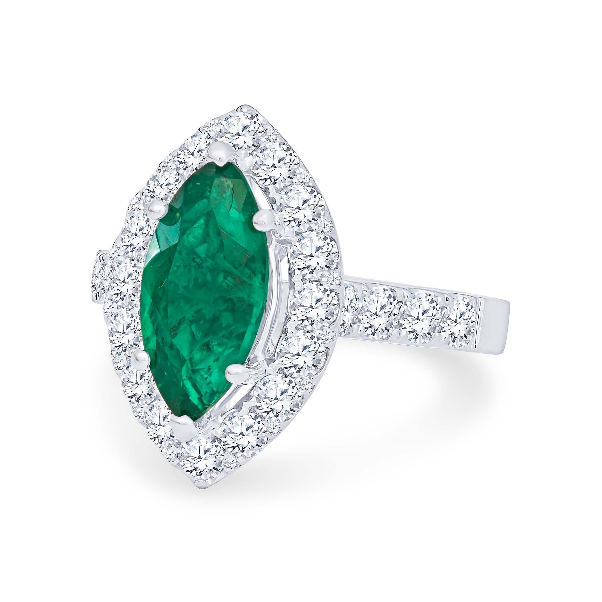 Gorgeous 2.17 carat marquise shaped Columbian emerald that is beautifully surrounded by 1.40 carats total weight in round brilliant cut diamonds that have been perfectly set in halo form. The ring was designed and crafted by our master jewelers in