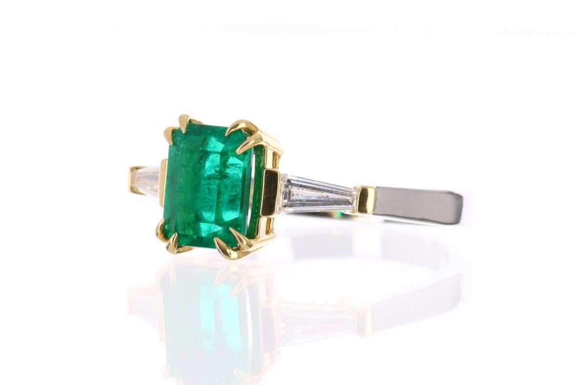 Setting Style: Three Stone
Setting Material: 18K Yellow & White Gold
Gold Weight: 5.3 Grams

Main Stone: Emerald
Shape: Emerald Cut
Weight: 1.85-Carats
Clarity: Transparent
Color: Vivid Dark Green
Luster: Excellent
Origin: Colombia
Treatments: