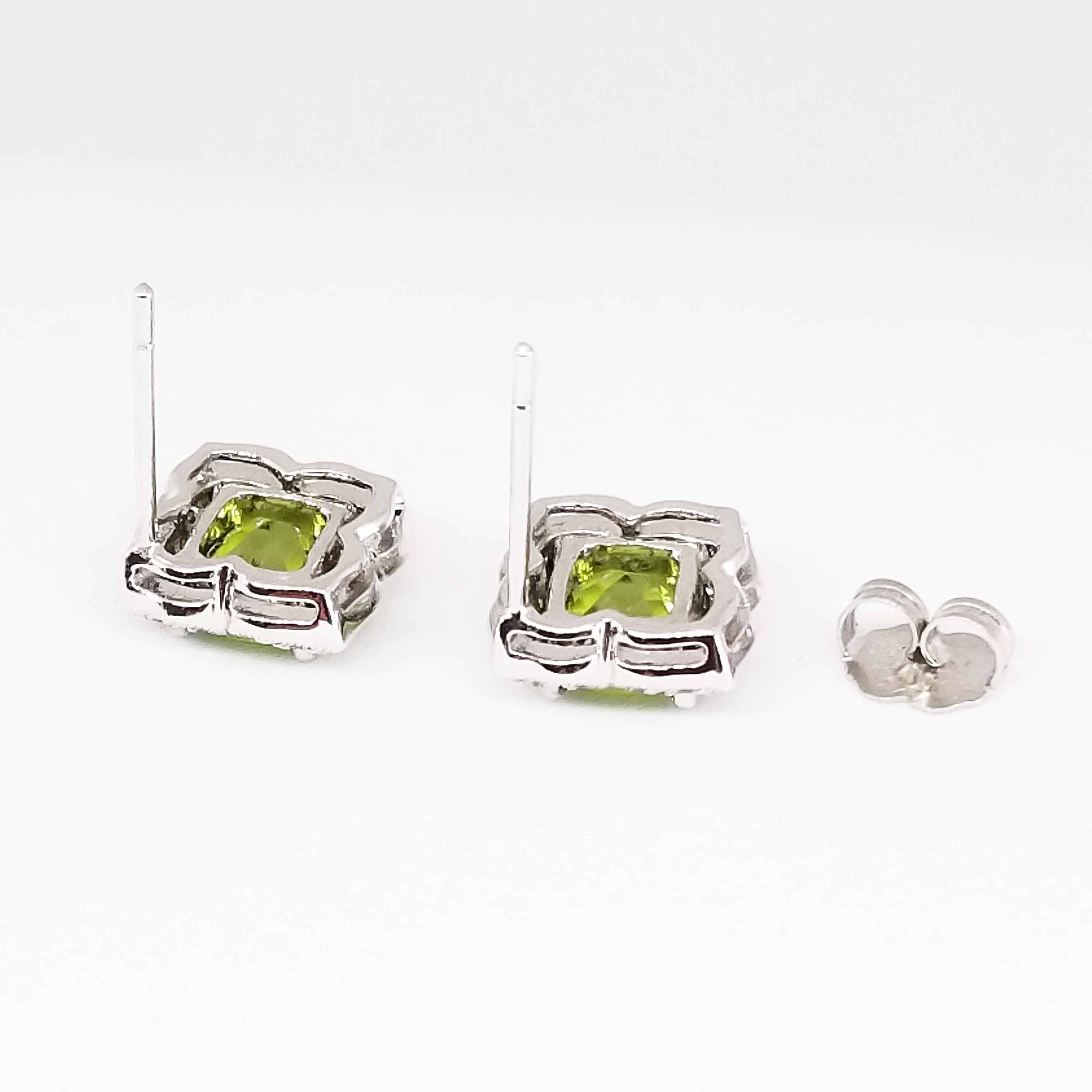 This Feminine pair of Clover Shaped Floret Earrings feature two Cushion Shape, Checkerboard Faceted Green Peridot of 2.18 Carats combined weight. The Gem Quality stones are of Grass Green hue and are prong set, surrounded by a Clover of Round