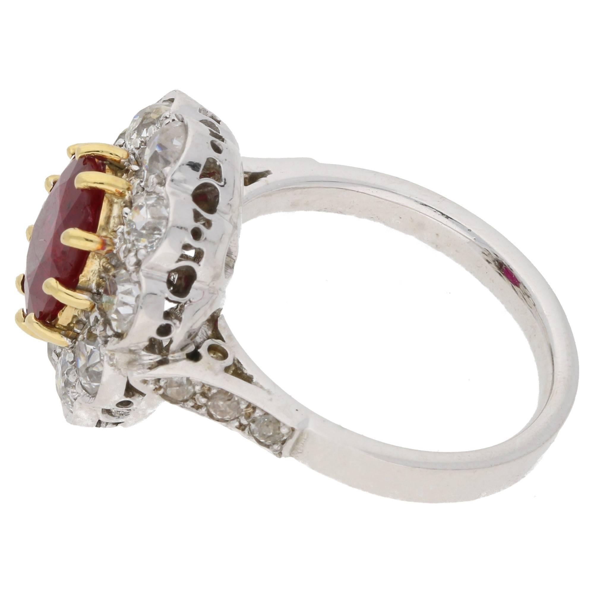 A beautiful red oval cut Thai ruby and diamond cluster ring set in 18ct yellow gold and platinum. 
The centrally set oval faceted Thai ruby is set in a ten-claw 18ct yellow gold mount, and is haloed by ten old European cut diamonds; these are set in