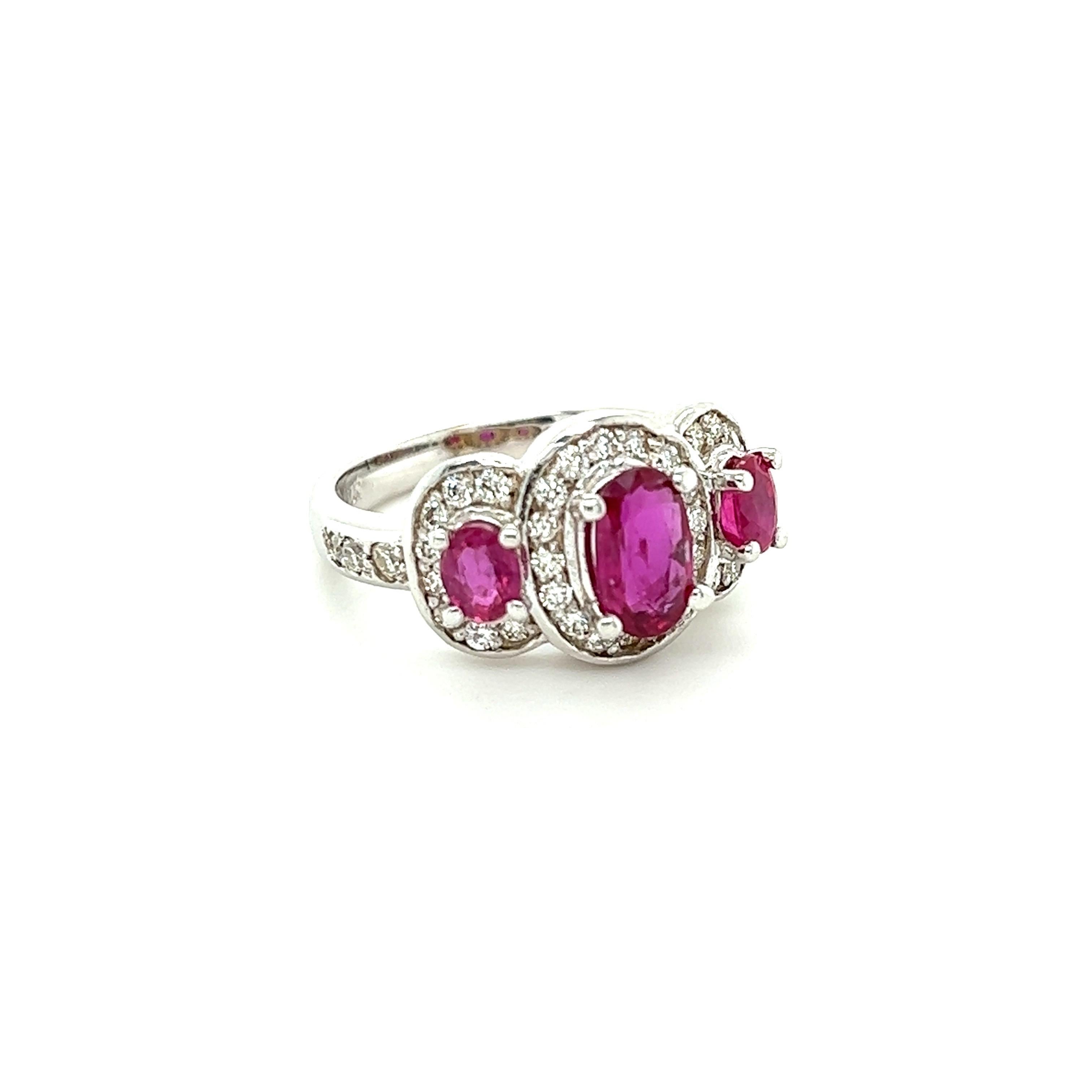 Anello a tre pietre con diamante e rubini che pesano 1,62 carati e il rubino centrale misura 7,5 mm x 5 mm. Ci sono anche 38 diamanti taglio rotondo che pesano 0,56 carati. (Chiarezza: VS, Colore: H) Il peso totale dell'anello è di 2.18 carati.