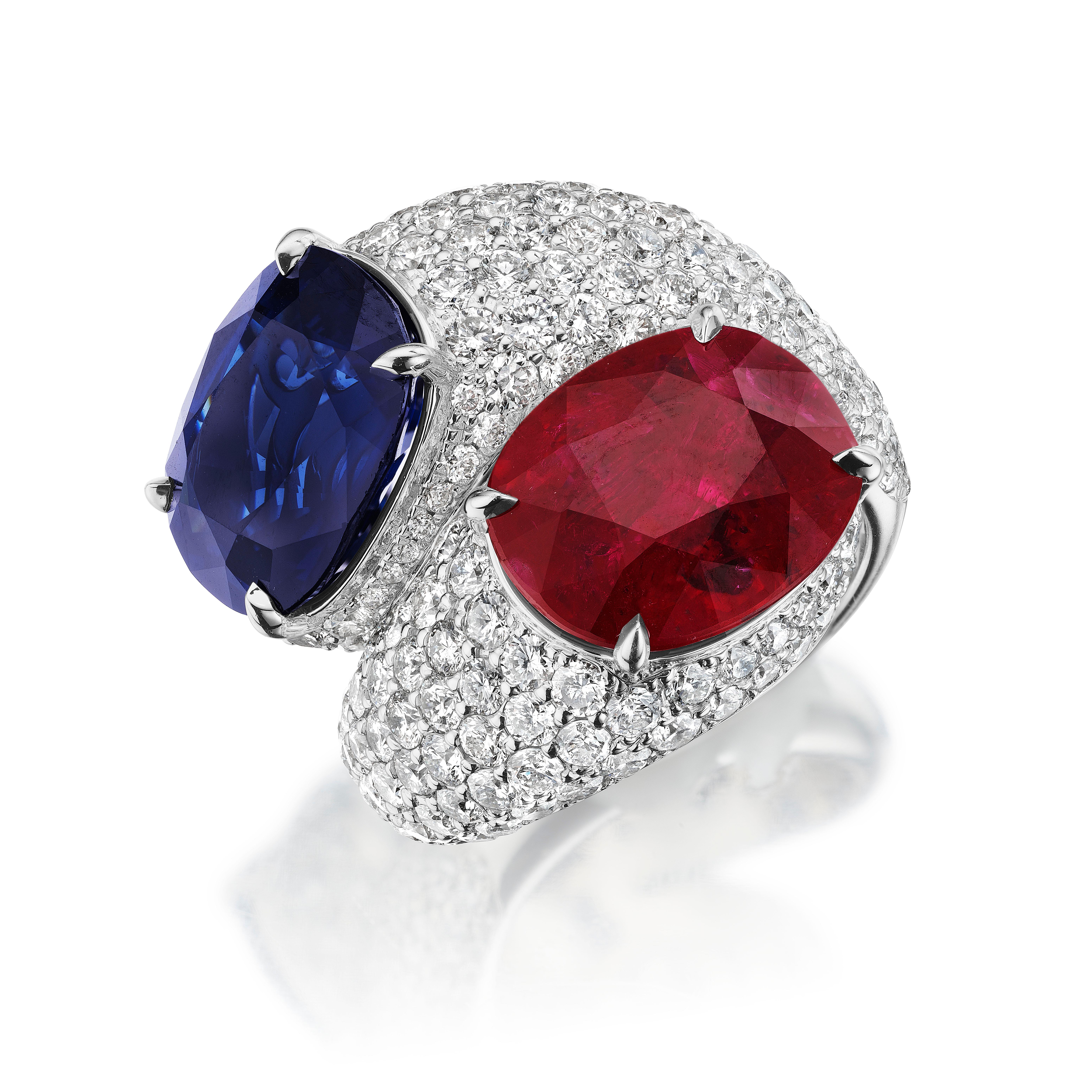 The pinnacle of excellence and design are captured in this platinum ruby & sapphire bypass ring. This handmade modern design showcases an exceptional deep vivid blue Sri Lankan 8.70 carat sapphire balanced by an 8.11 carat vivid natural Mozambique