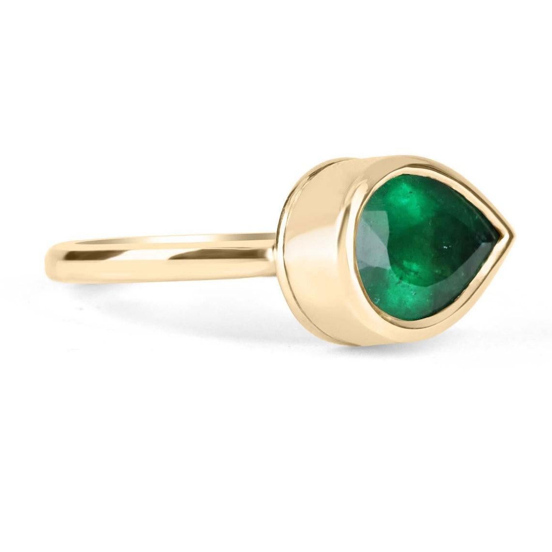 This ring is not for the faint of heart! Displayed is a Colombian emerald bezel-set, teardrop solitaire ring in 18K gold. This gorgeous solitaire ring carries a full 7.0-carat emerald that will have you gazing at its mystic beauty. This large gem