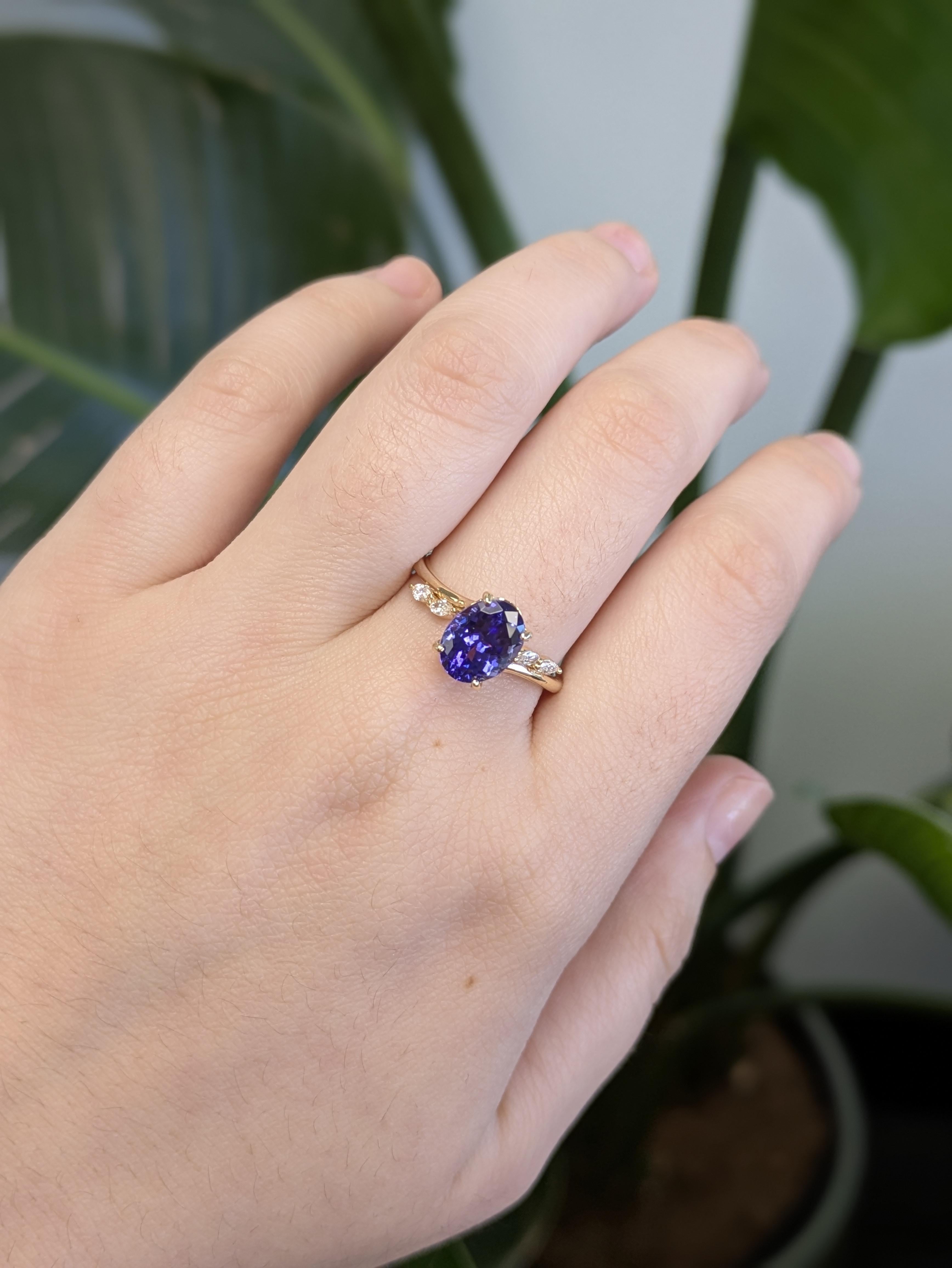 Questo elegante anello in oro giallo 14K ha al centro un'affascinante tanzanite dal taglio ovale, accentuata da scintillanti diamanti naturali. Le ricche sfumature blu-viola della tanzanite contrastano magnificamente con la calda montatura in oro,