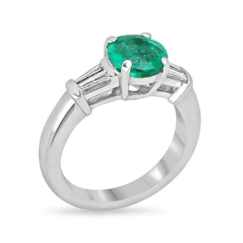 Celebrate your love with this stunning emerald and diamond engagement ring. A radiant 1.90-carat round-cut emerald, sourced from Colombia, steals the spotlight with its vivid medium-green hue and remarkable qualities. Set in a secure four-prong