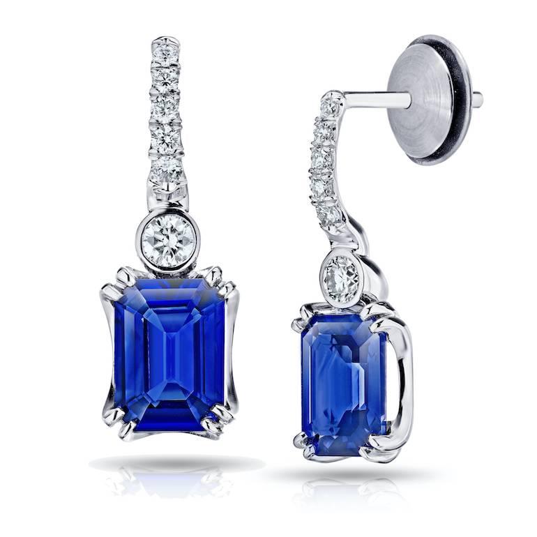 Two matching emerald cut blue sapphires weighing 2.19 carats set with twelve round brilliant cut diamonds weighing .19 carats set in hand made platinum earrings
