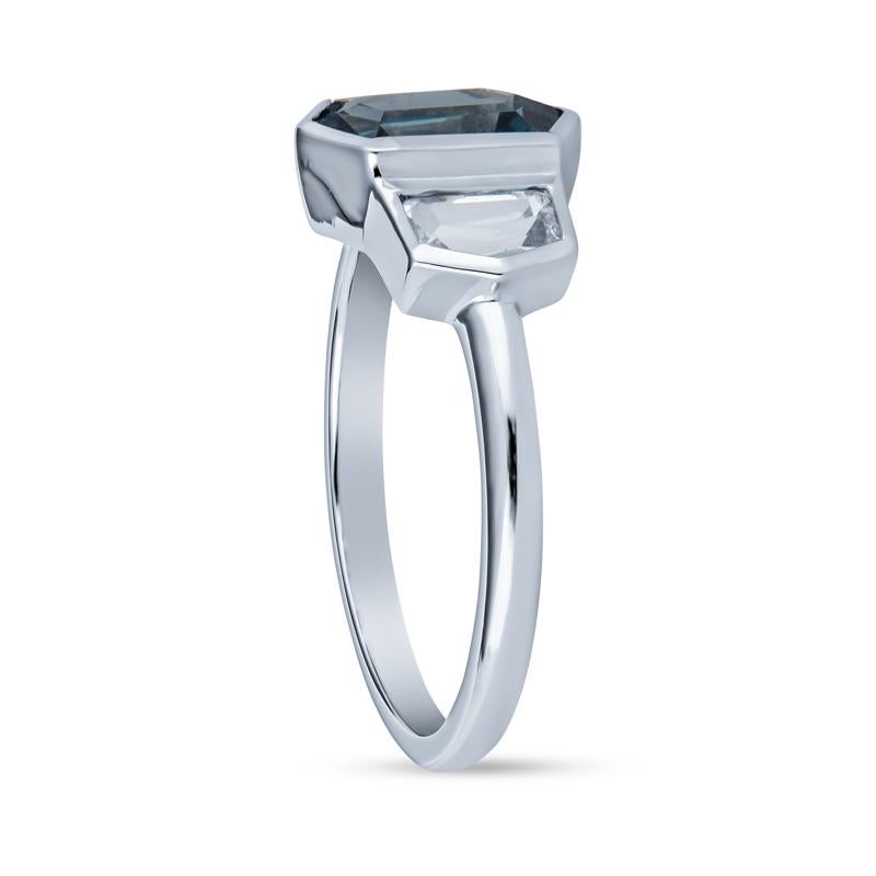 This ring features a 2.19 carat hexagonal shaped natural blue sapphires accented by two trapezoid white sapphires. They are bezel set in platinum and set on a dainty band to make the stones shine!. This ring is a size 7 but can be resized upon