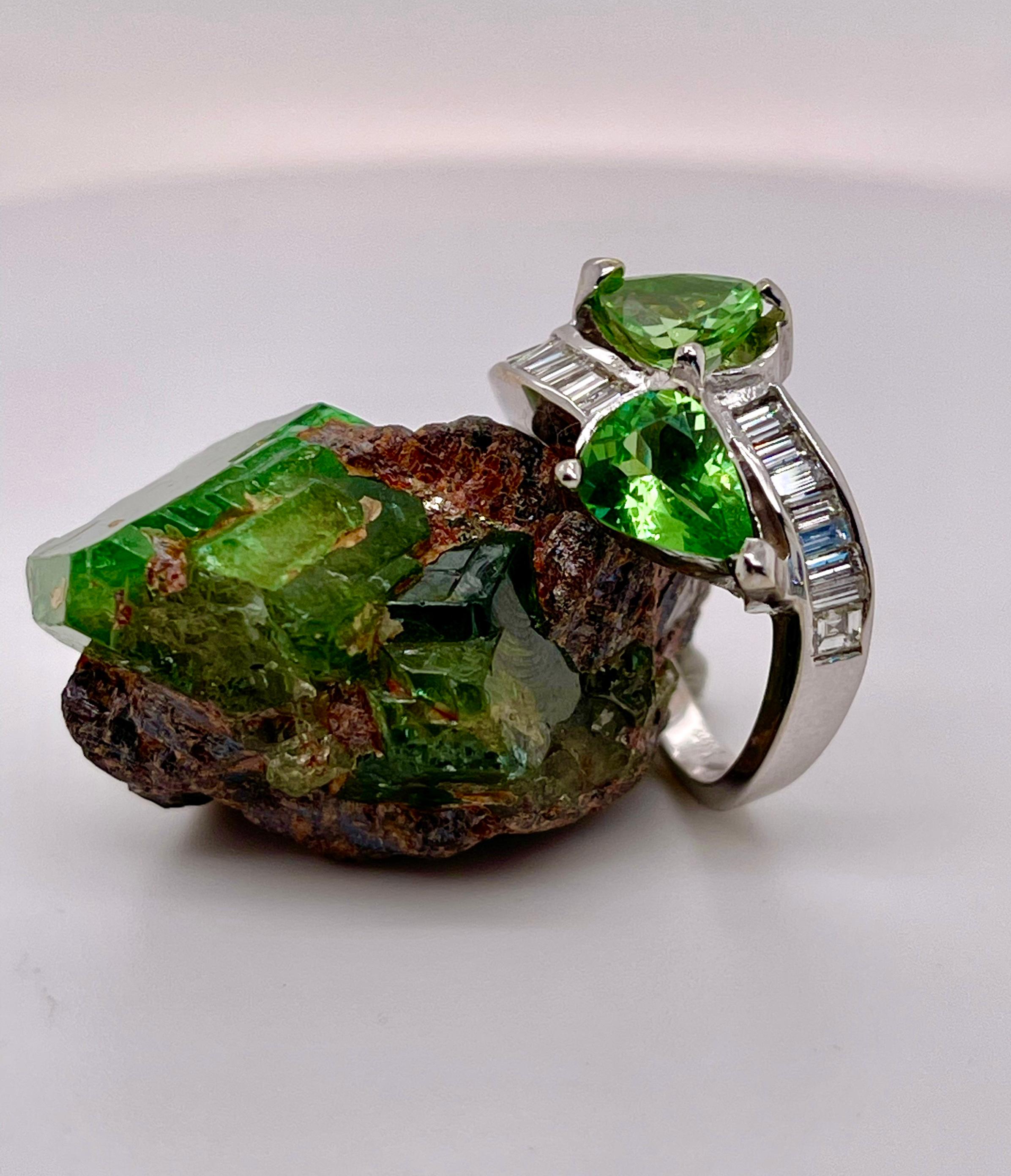 When Elke saw this bypass ring, she thought it would look great with a pair of pear Tsavorite Garnets. So instead of making a pair of earrings, we set this 2.19 carats pair in a ring. 

The ring is done in 14-karat white gold with 15 small baguette