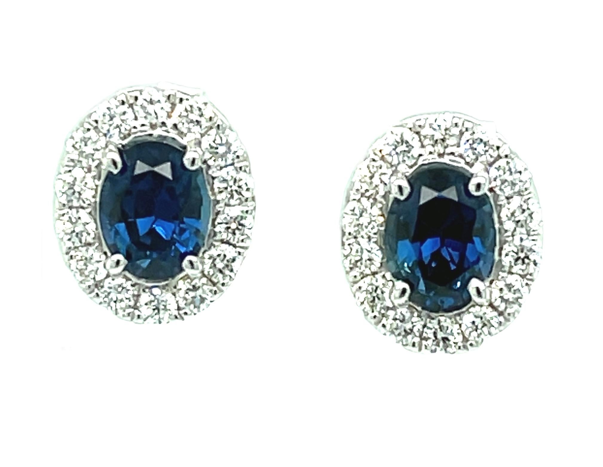 These luxurious sapphire and diamond earrings feature a beautifully matched pair of oval blue sapphires framed by halos of oversized round brilliant diamonds! This is a stunning pair of earrings that will be your 