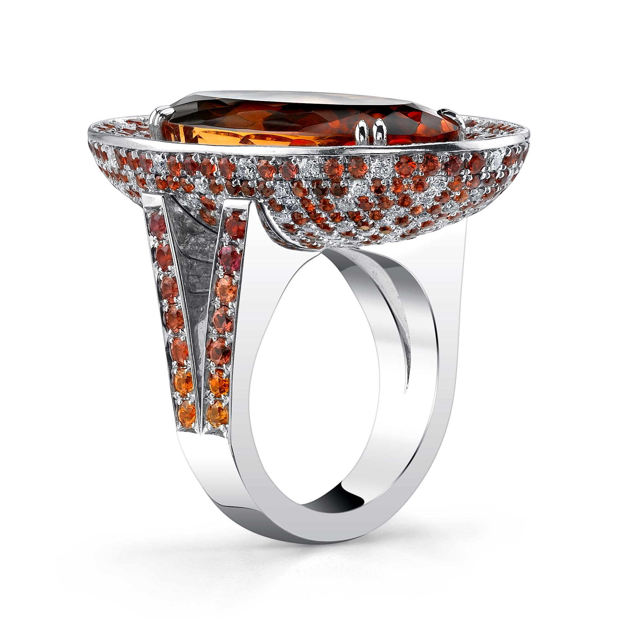 Introducing the Precious Imperial Topaz Ring, set in 18 Karat White Gold and accented with dazzling White Diamonds and Orange Sapphires. The GIA certified center stone boasts a magnificent reddish-orange color with slightly pinkish undertones,
