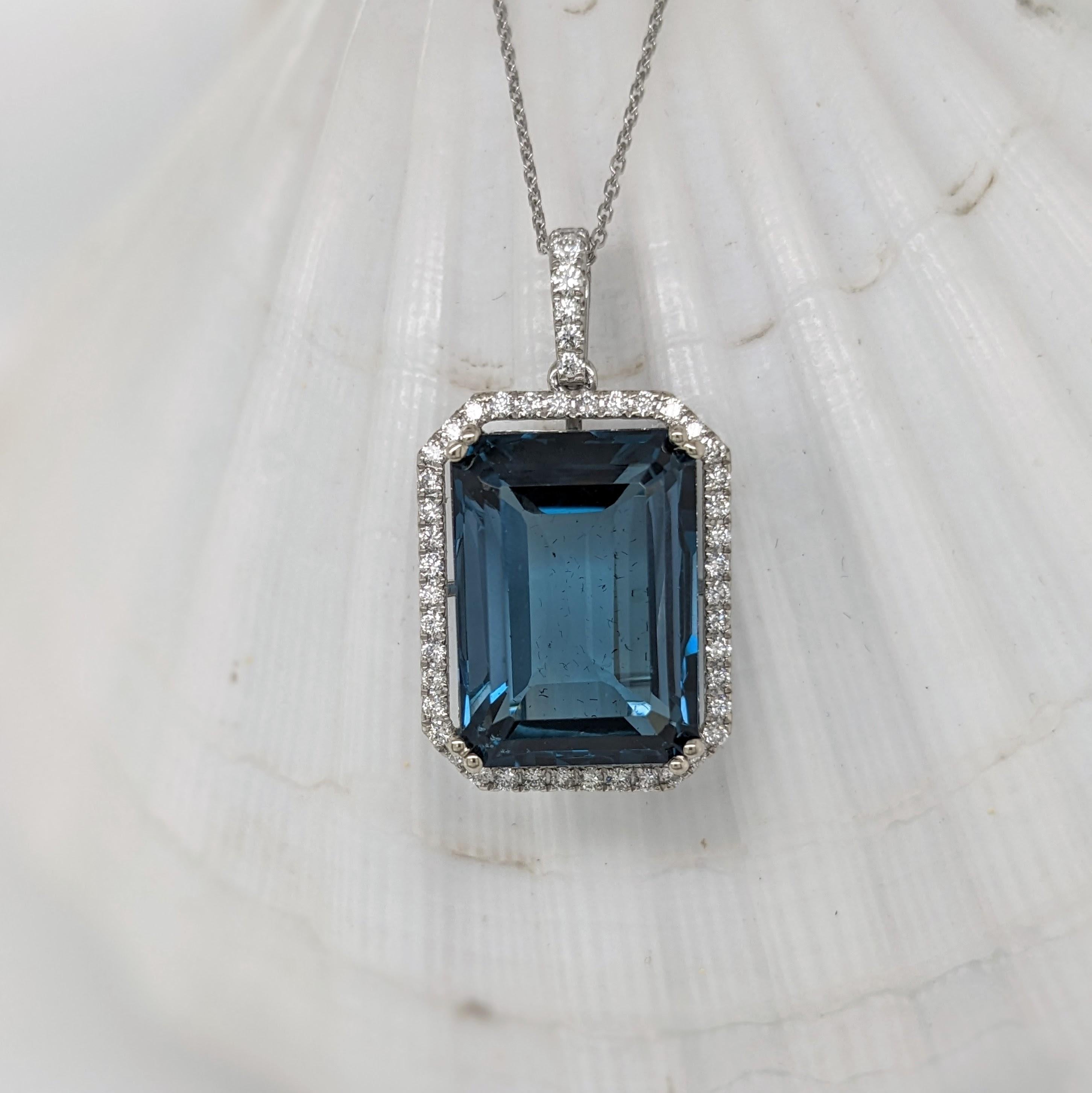 This beautiful statement pendant features a 21.41 carat emerald cut london topaz gemstone with a halo of natural earth mined diamonds and diamond studded bail, all set in solid 14K gold. This pendant can be a lovely November birthstone gift for your